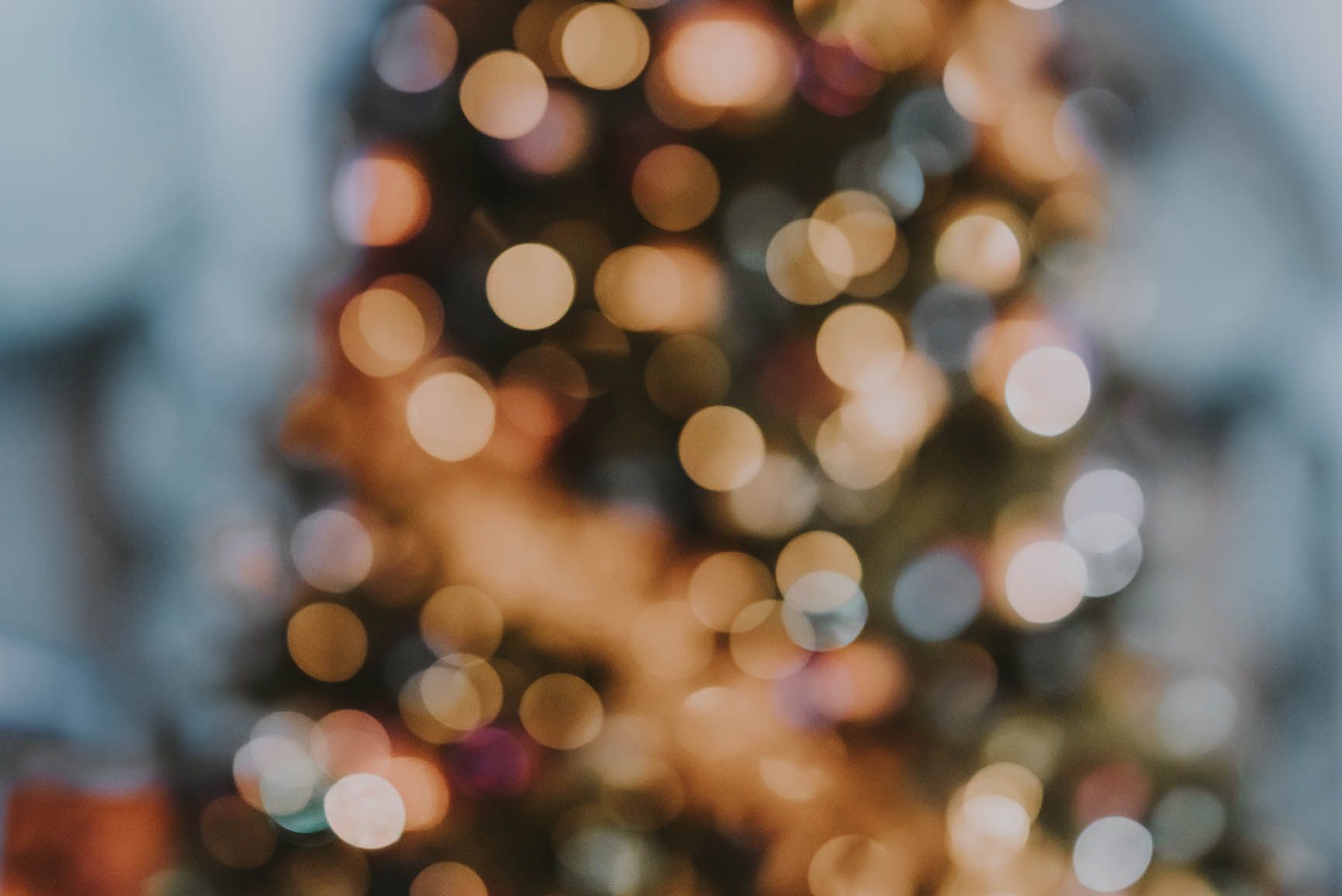 A blurred out Christmas tree with lights on it. - December