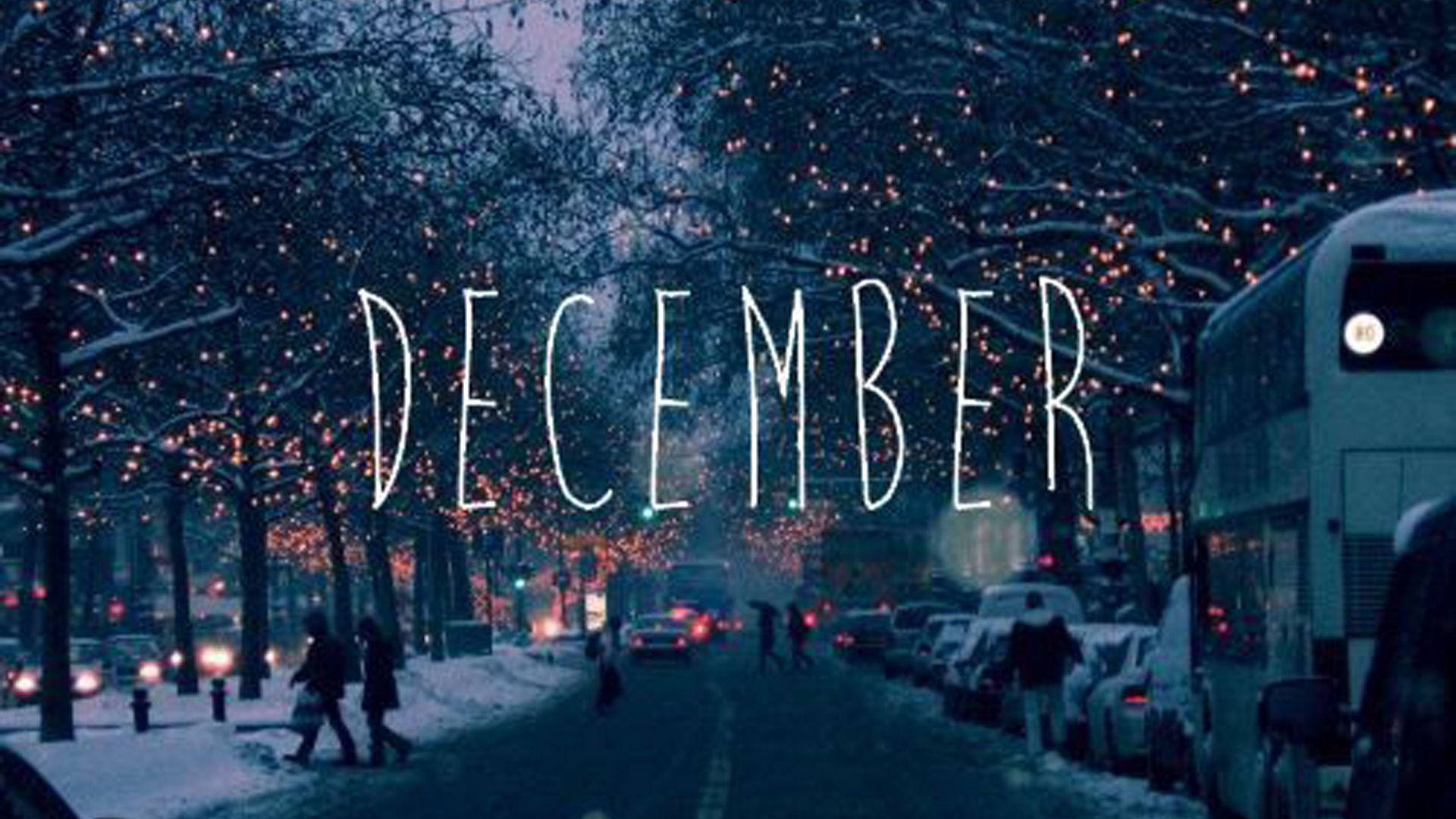The word december is written on a dark city street - December