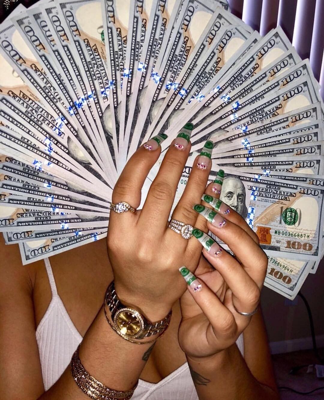 A woman holding up many green bills - Money