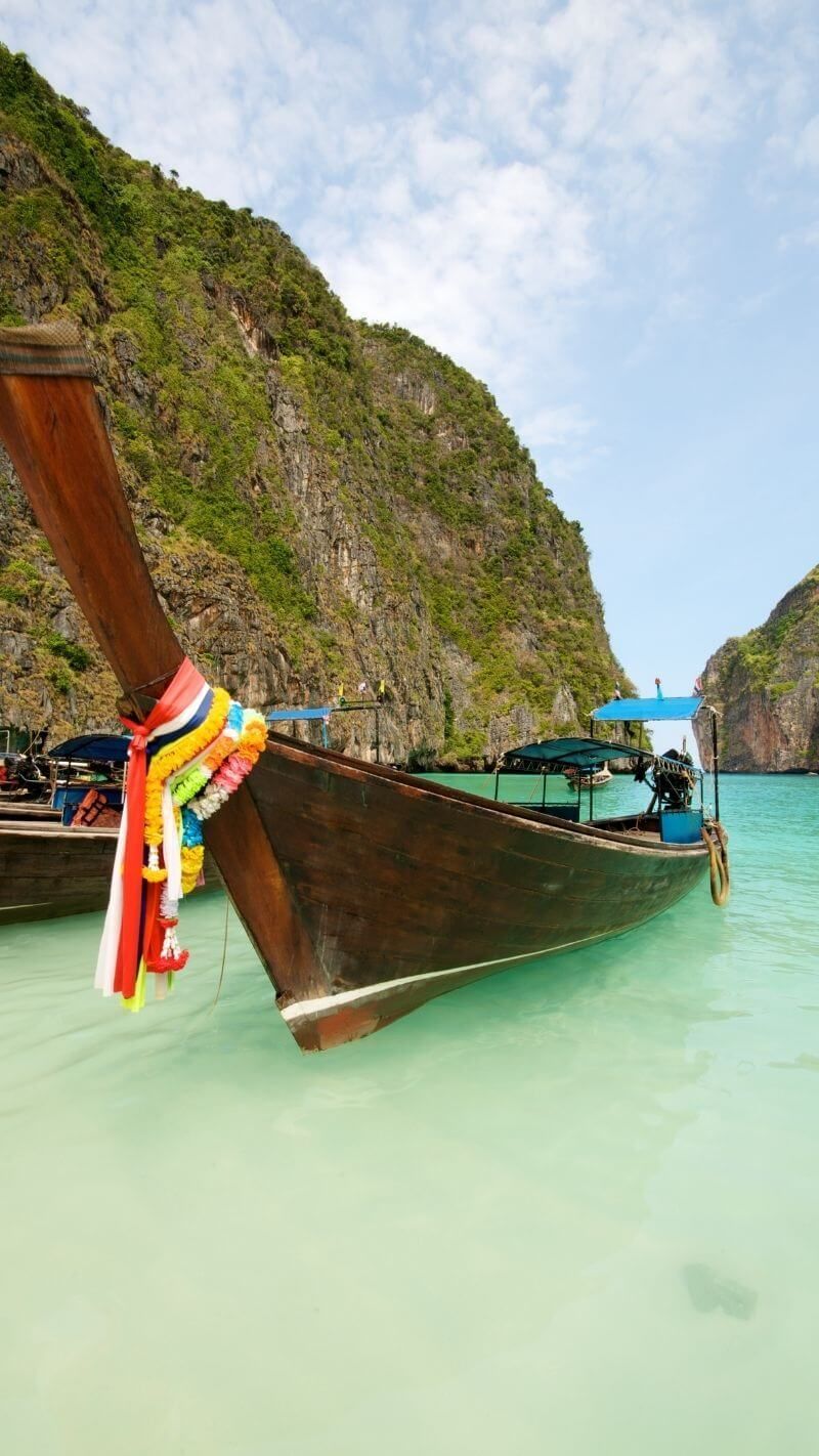 Longtail boats in Maya Bay, Thailand, a popular destination for travelers in Southeast Asia. - Travel