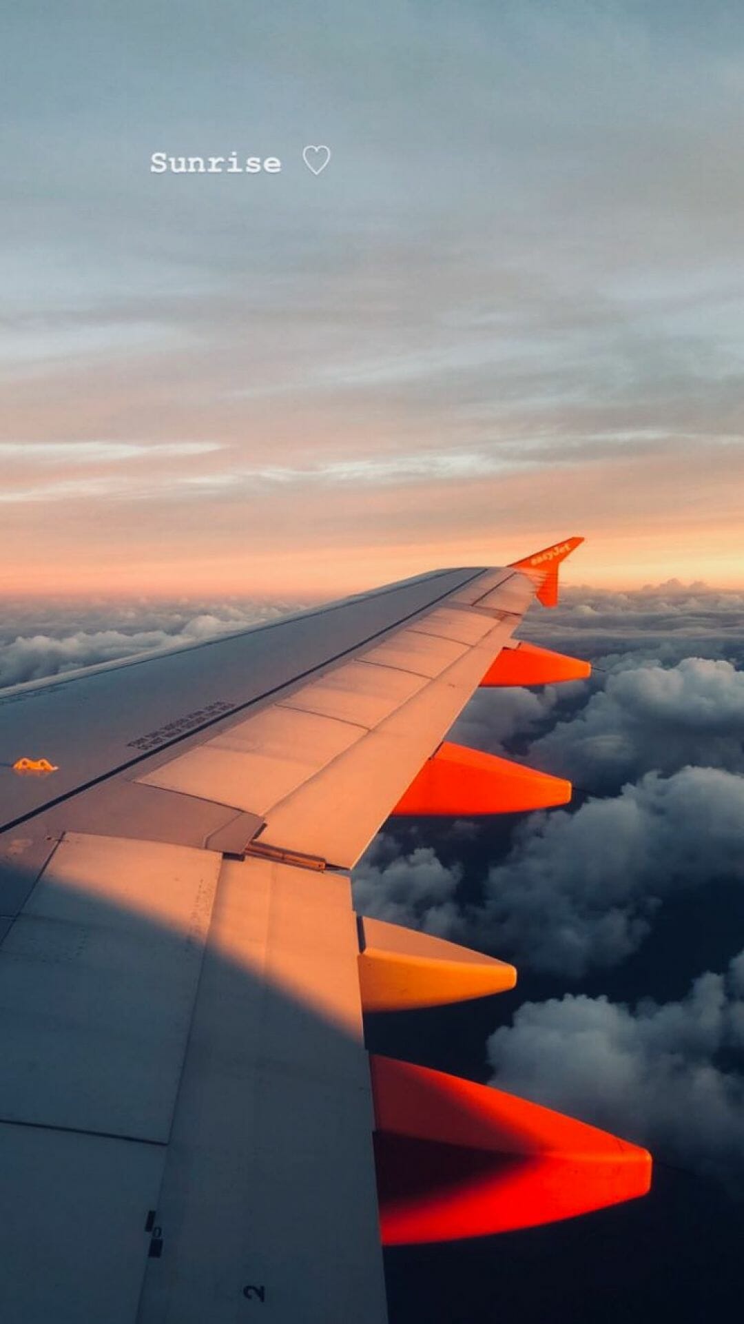 A plane wing with the sun setting in background - Travel