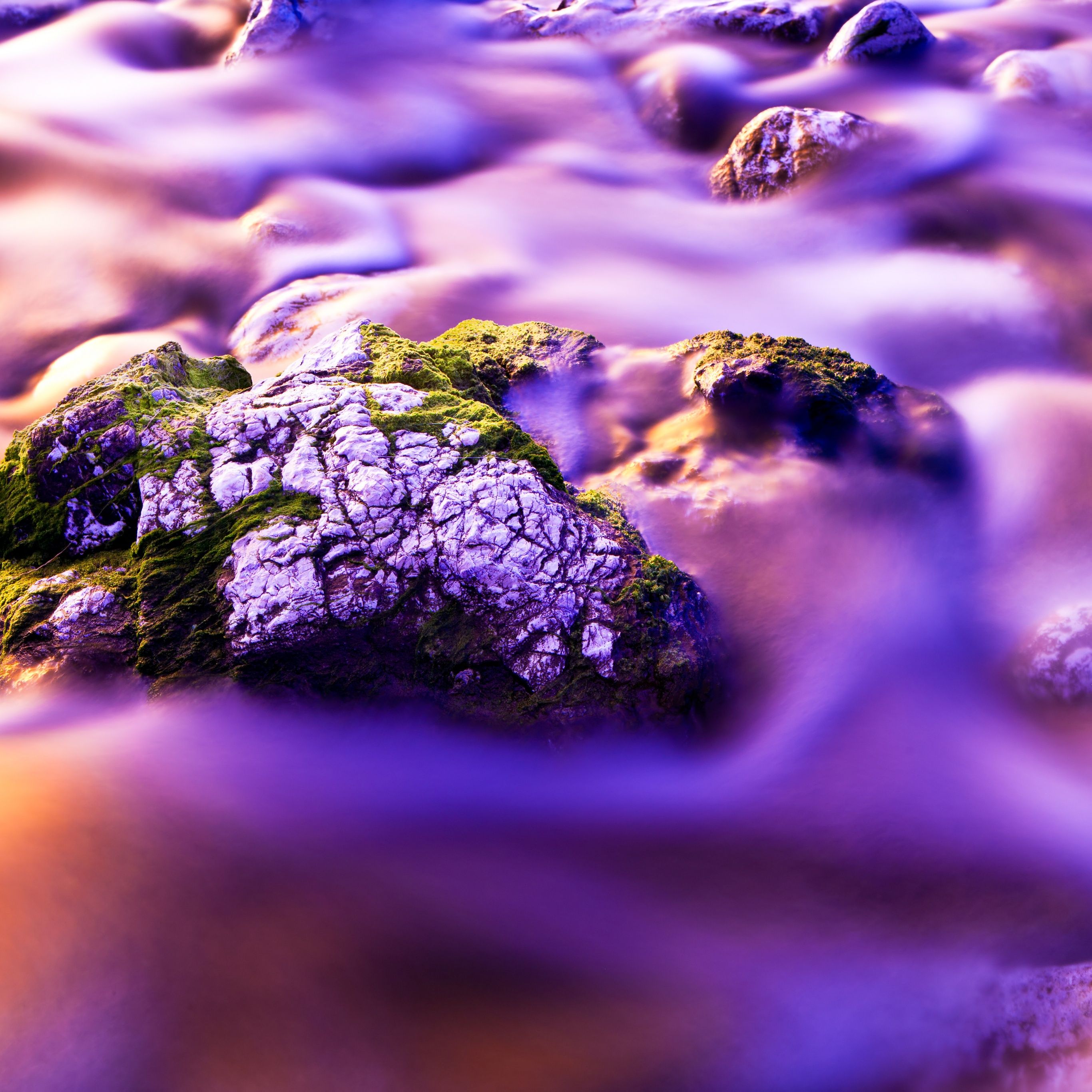 A river flowing over rocks, with a purple hue. - Water, rocks