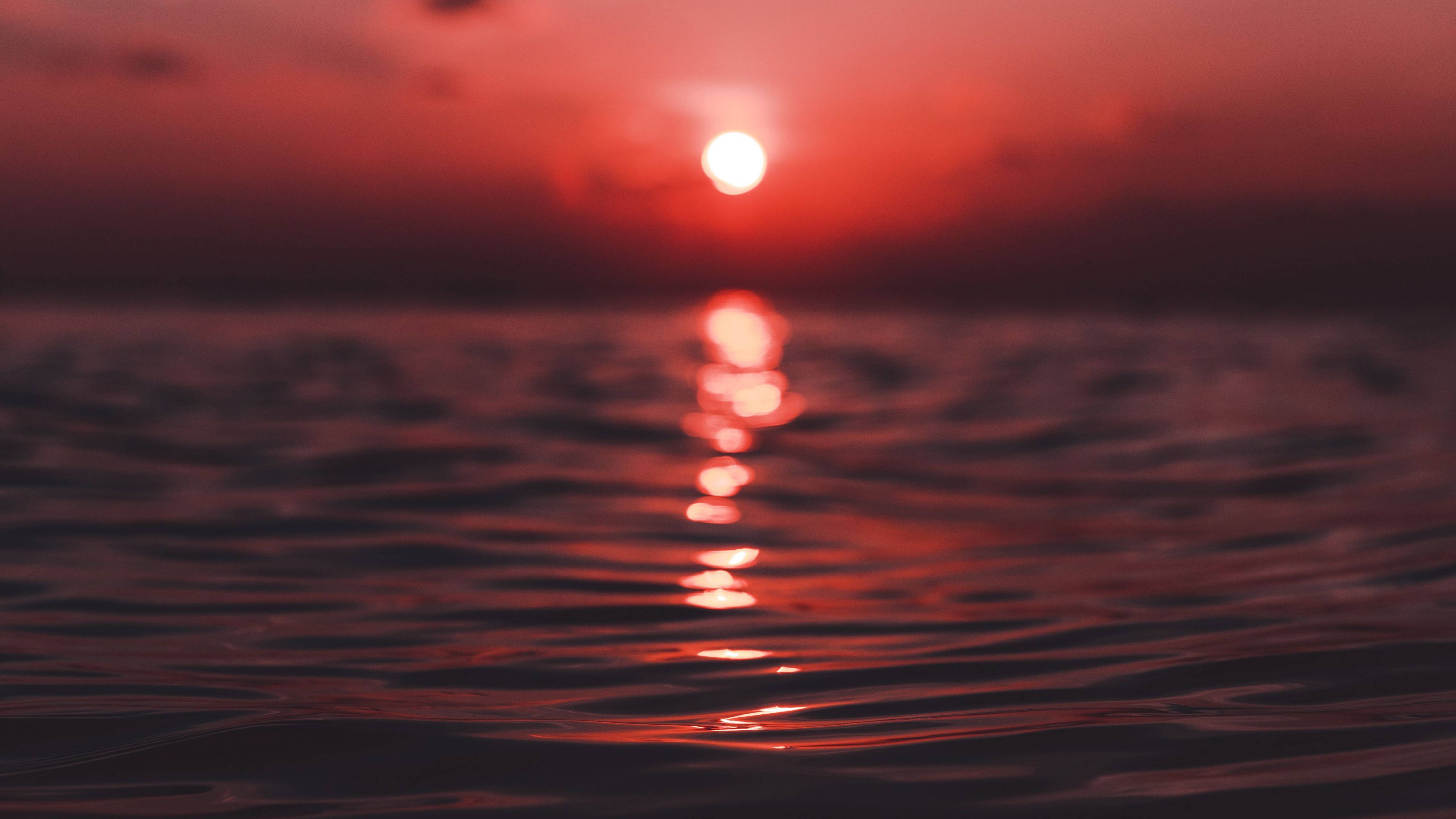 A beautiful sunset over the ocean with the sun setting behind the horizon and reflecting on the water. - Sunset, water