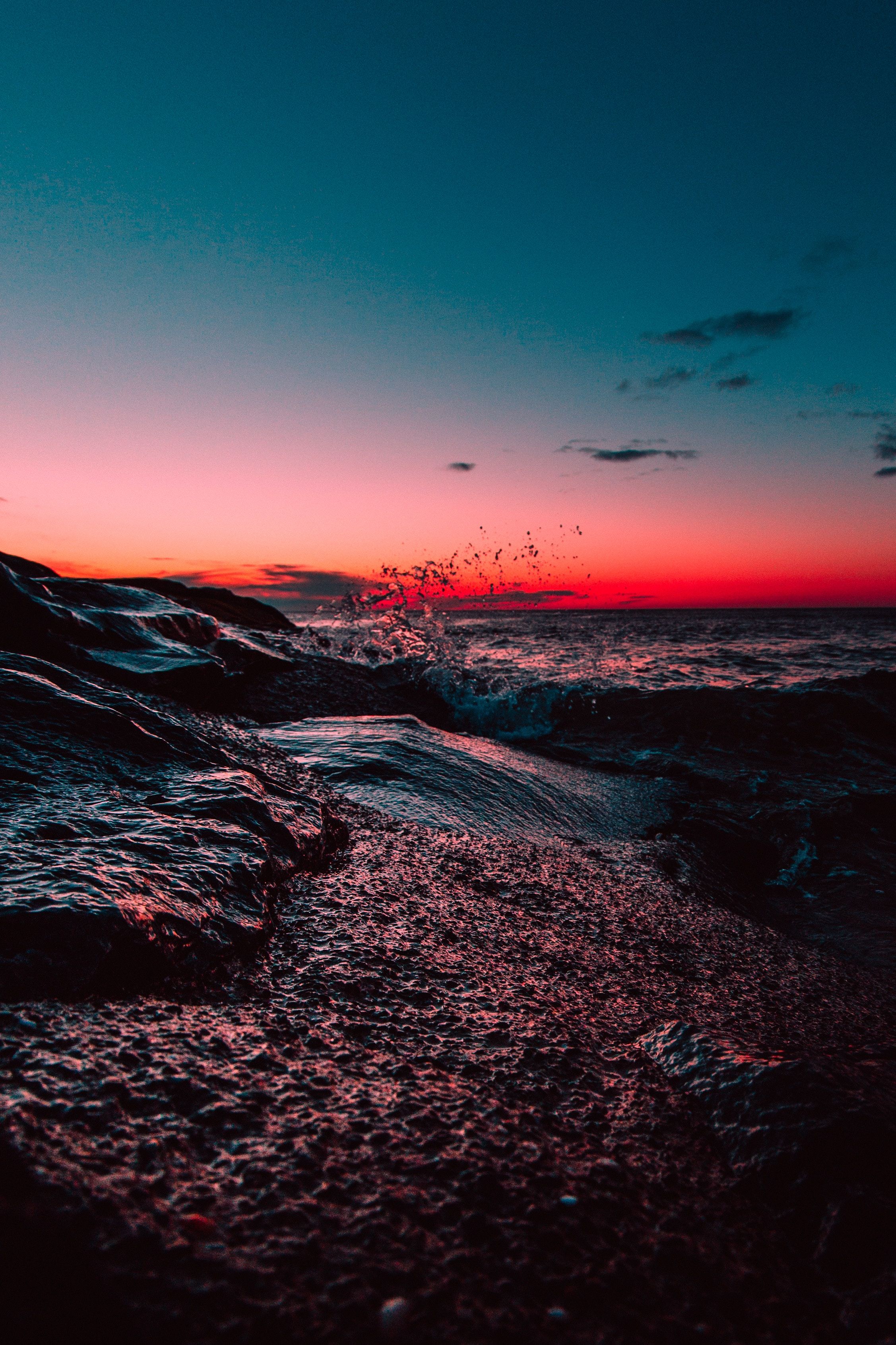 A sunset over the ocean with rocks in front - Beach, water, magic, sunset, beautiful, sunrise