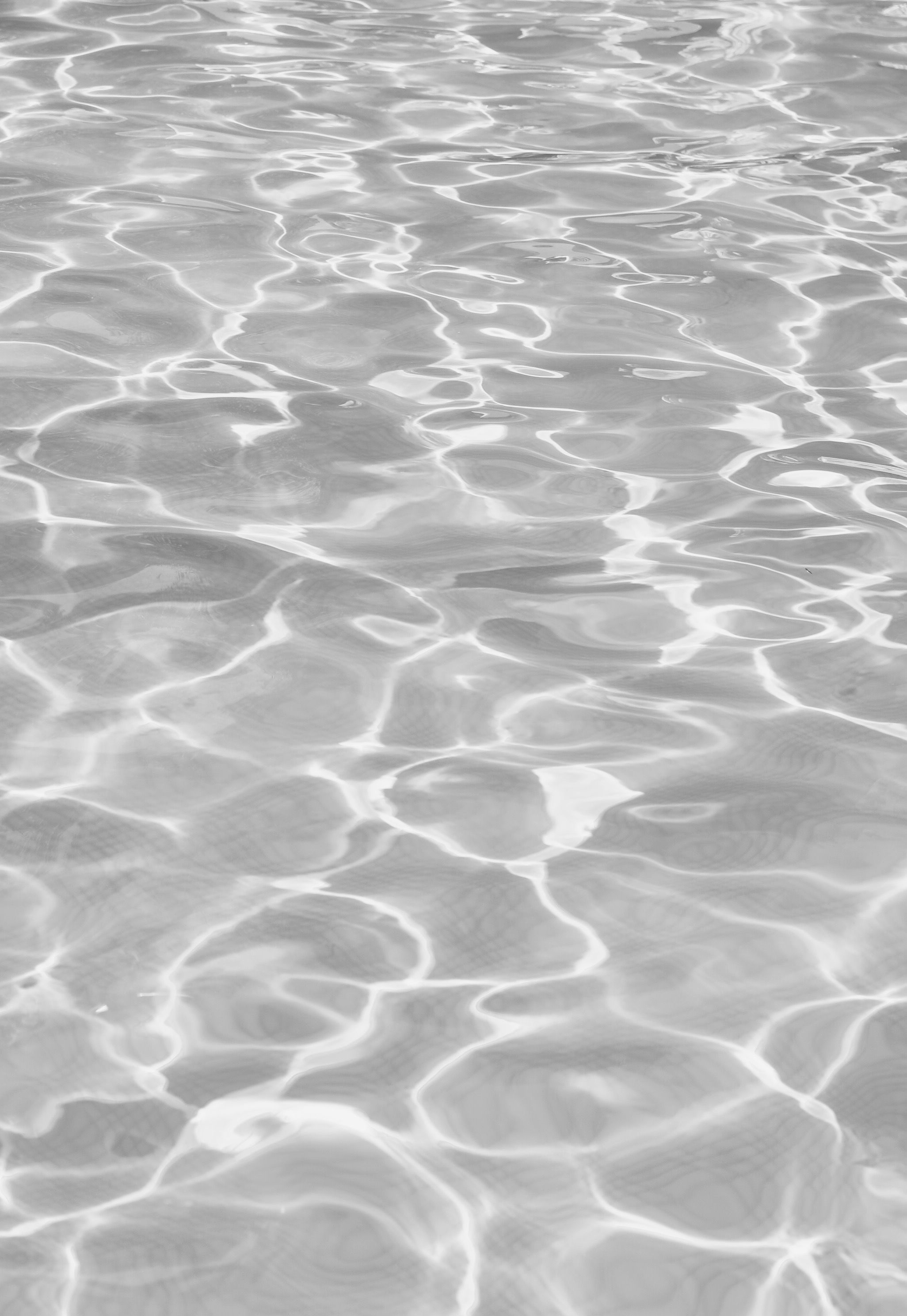A black and white photo of rippling water. - Gray, water, white