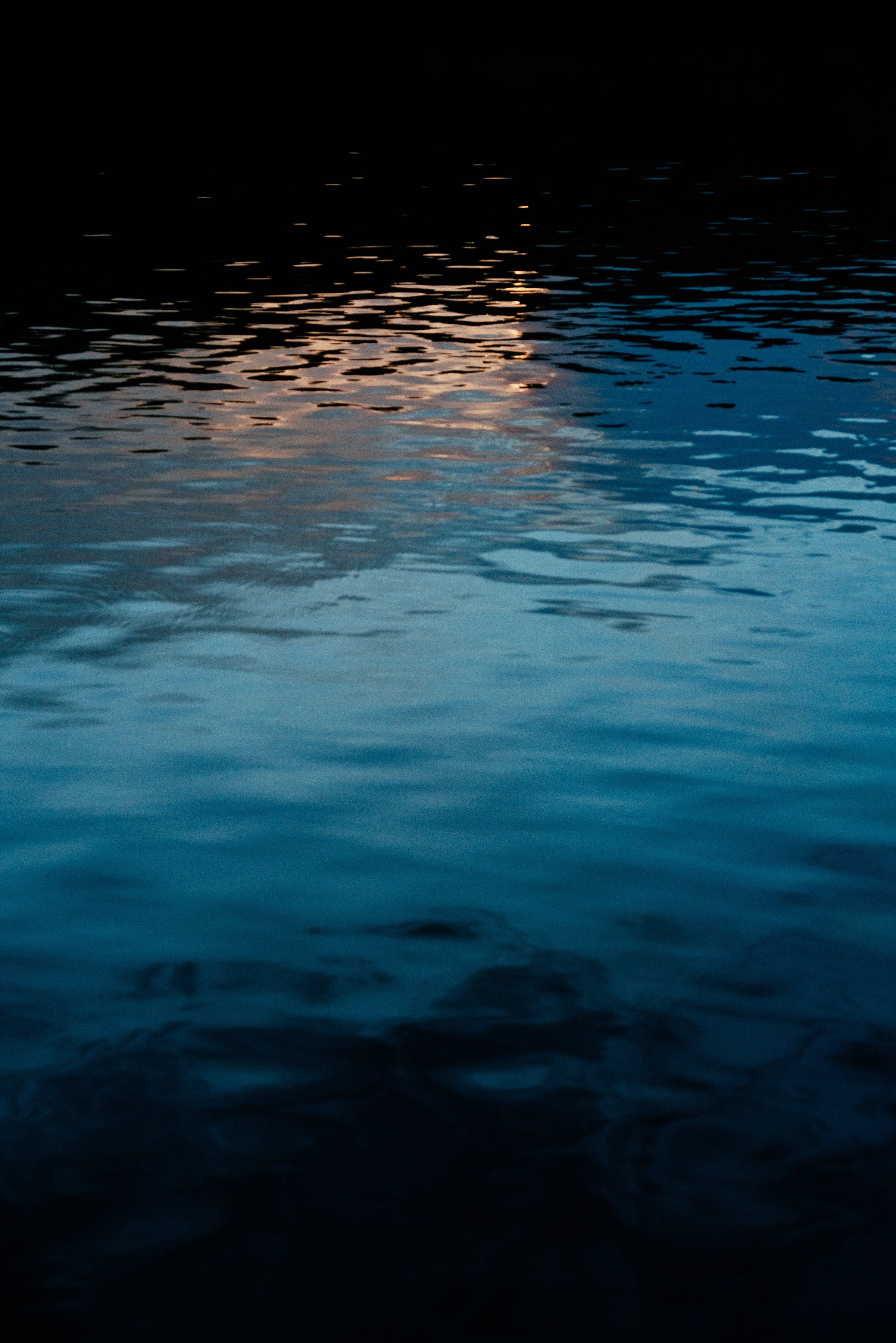 A reflection of the moon in the water at night. - Water
