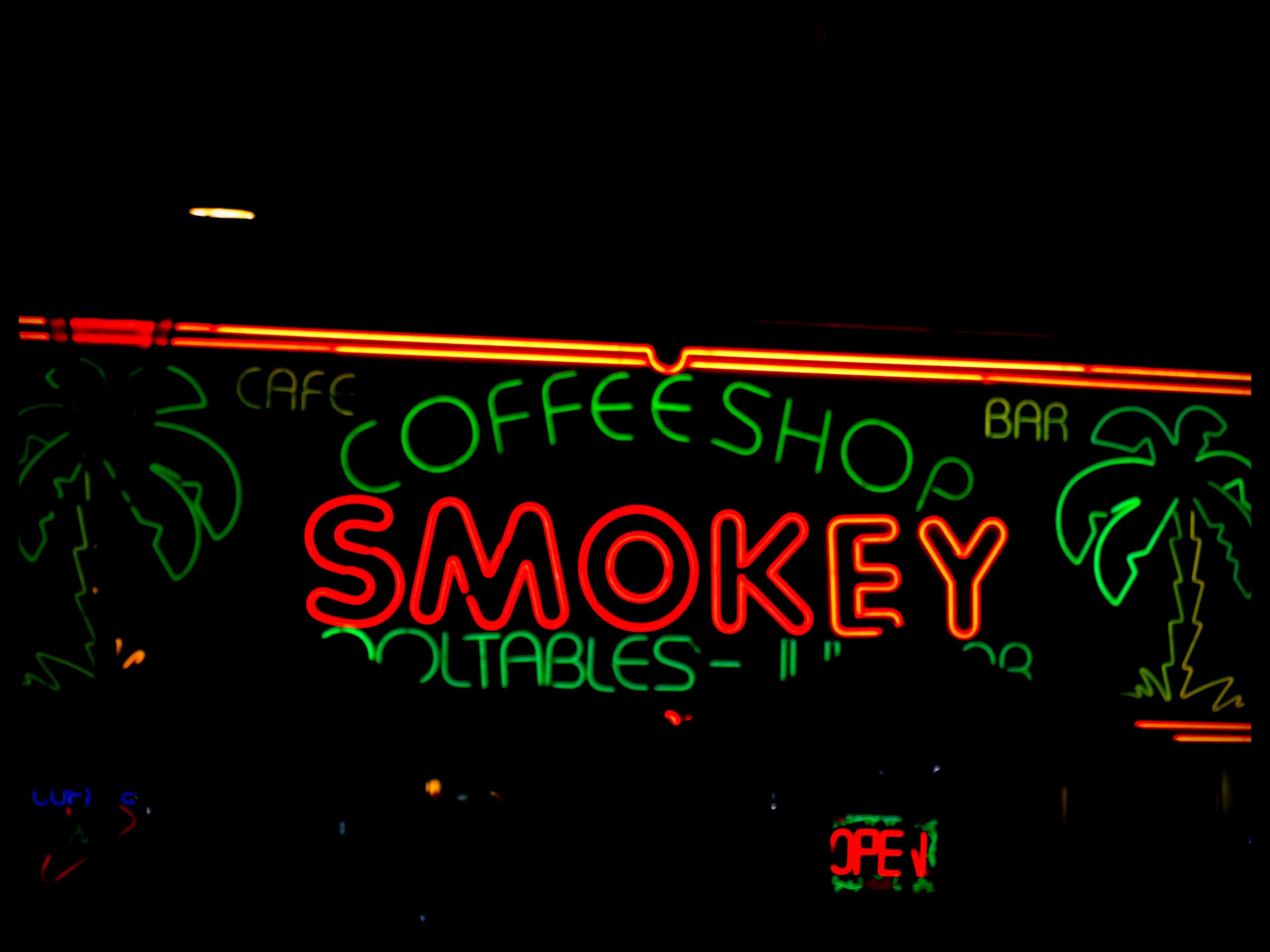 A neon sign that says smoky - Weed