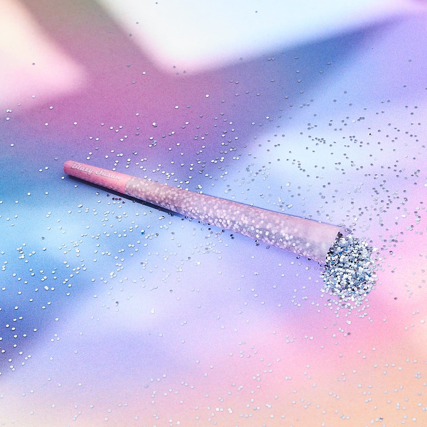 A pink and silver glittery makeup brush on a pastel background - Libra