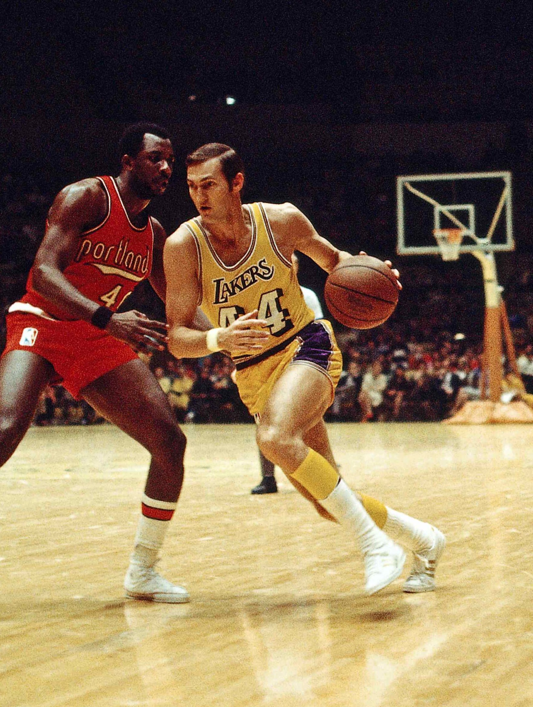 Jerry West dribbling the ball up the court in a game against the Portland Trailblazers. - NBA