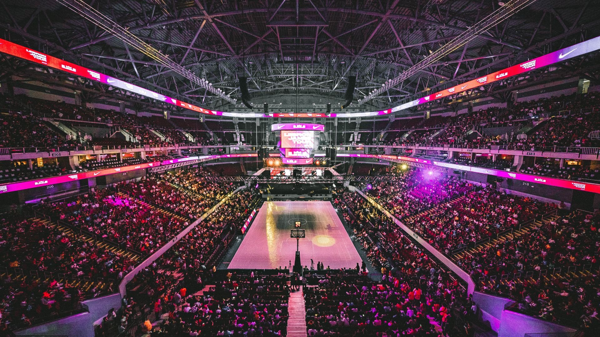 A packed out basketball stadium with purple lighting - NBA