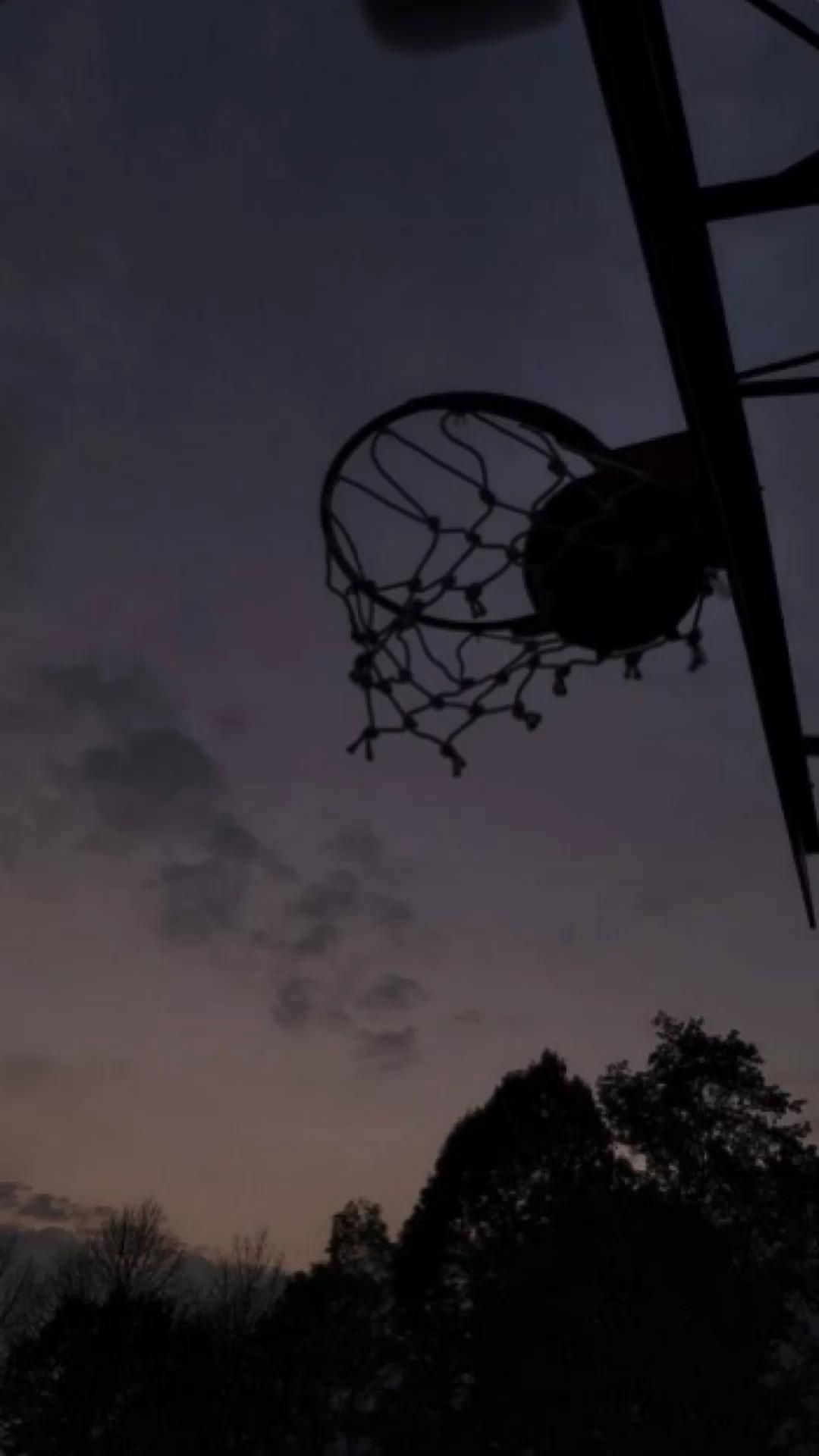 A basketball hoop is in the dark - Basketball