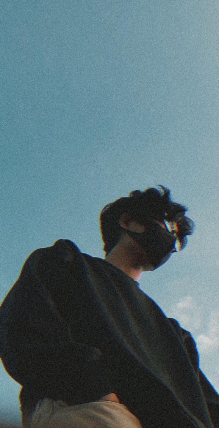 A person wearing a black jacket and glasses looking at the sky - Profile picture