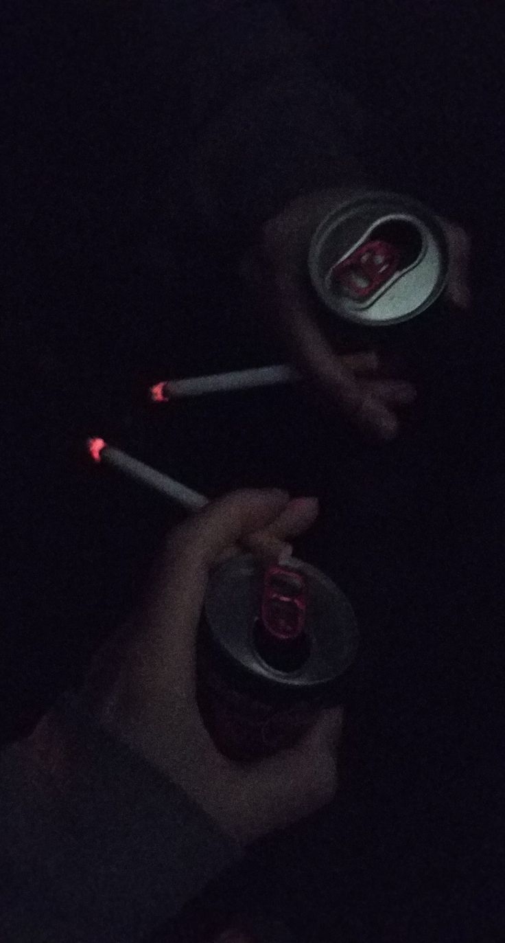A person holding two cans of soda - Smoke