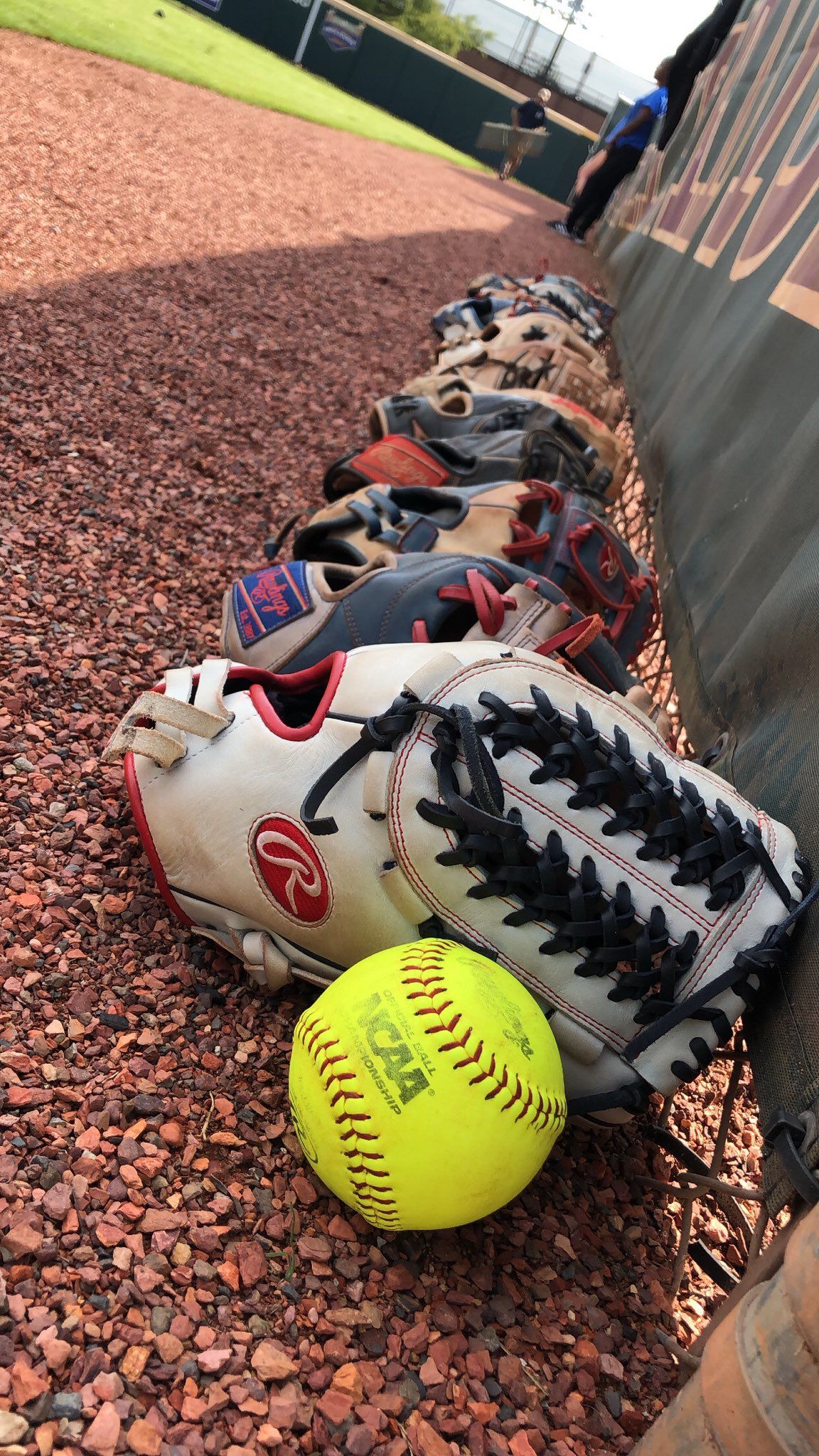 A baseball glove and ball on the ground - Softball