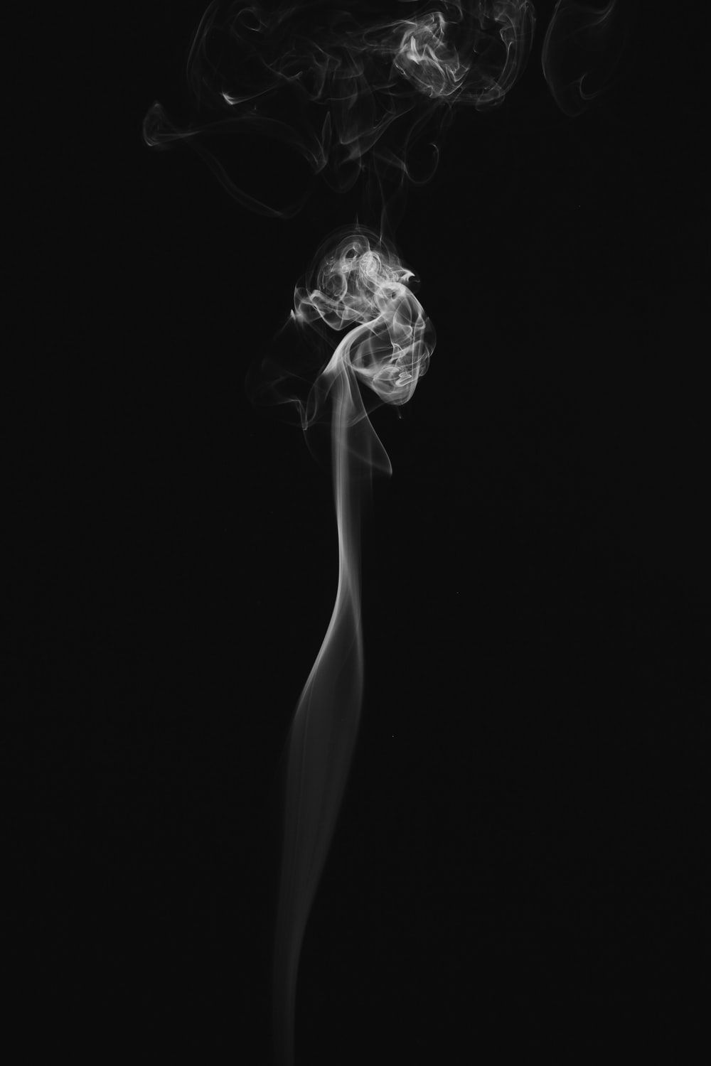 A black and white photo of smoke rising from a candle - Smoke