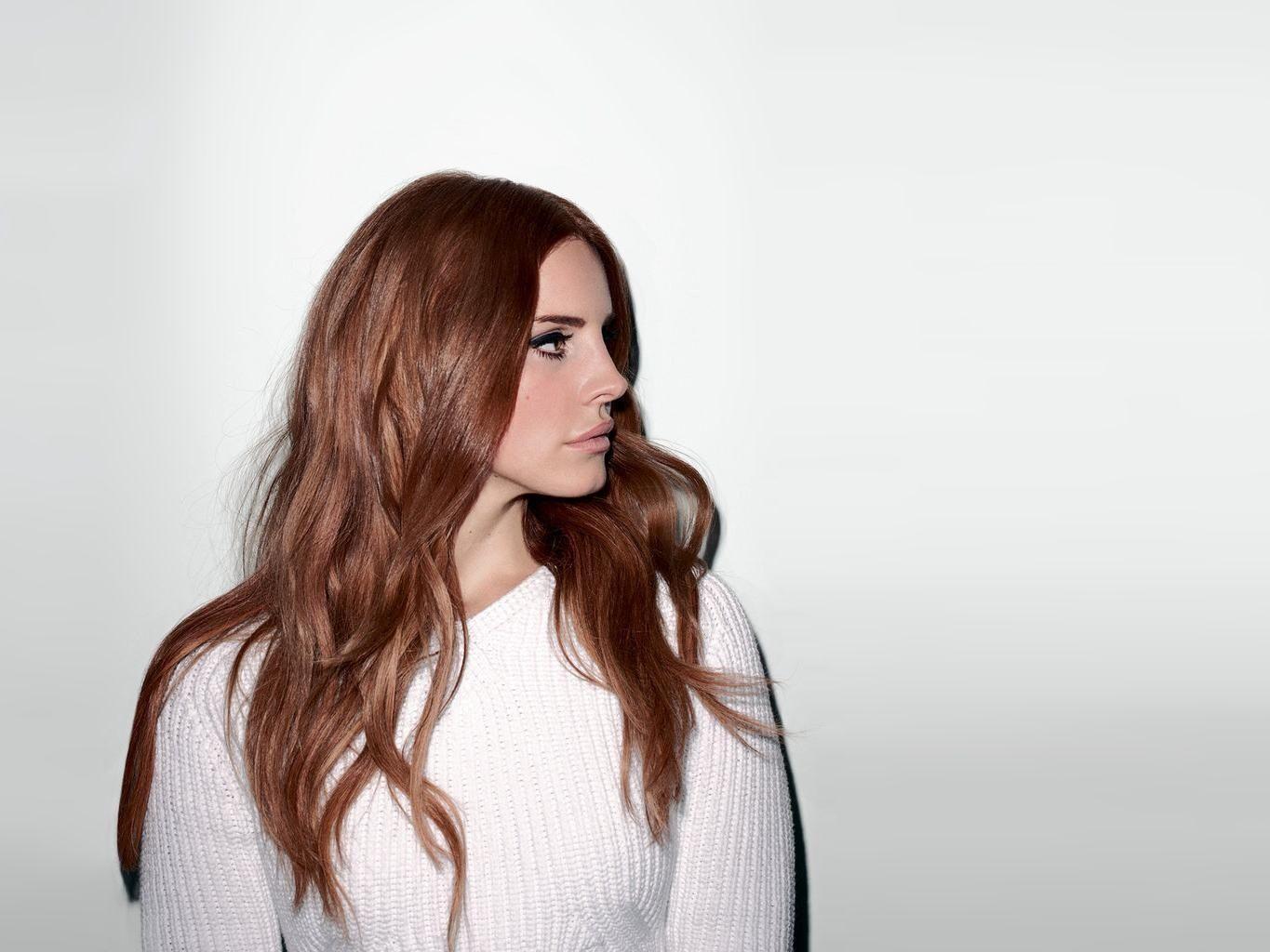 A woman with long red hair and wearing white - Lana Del Rey