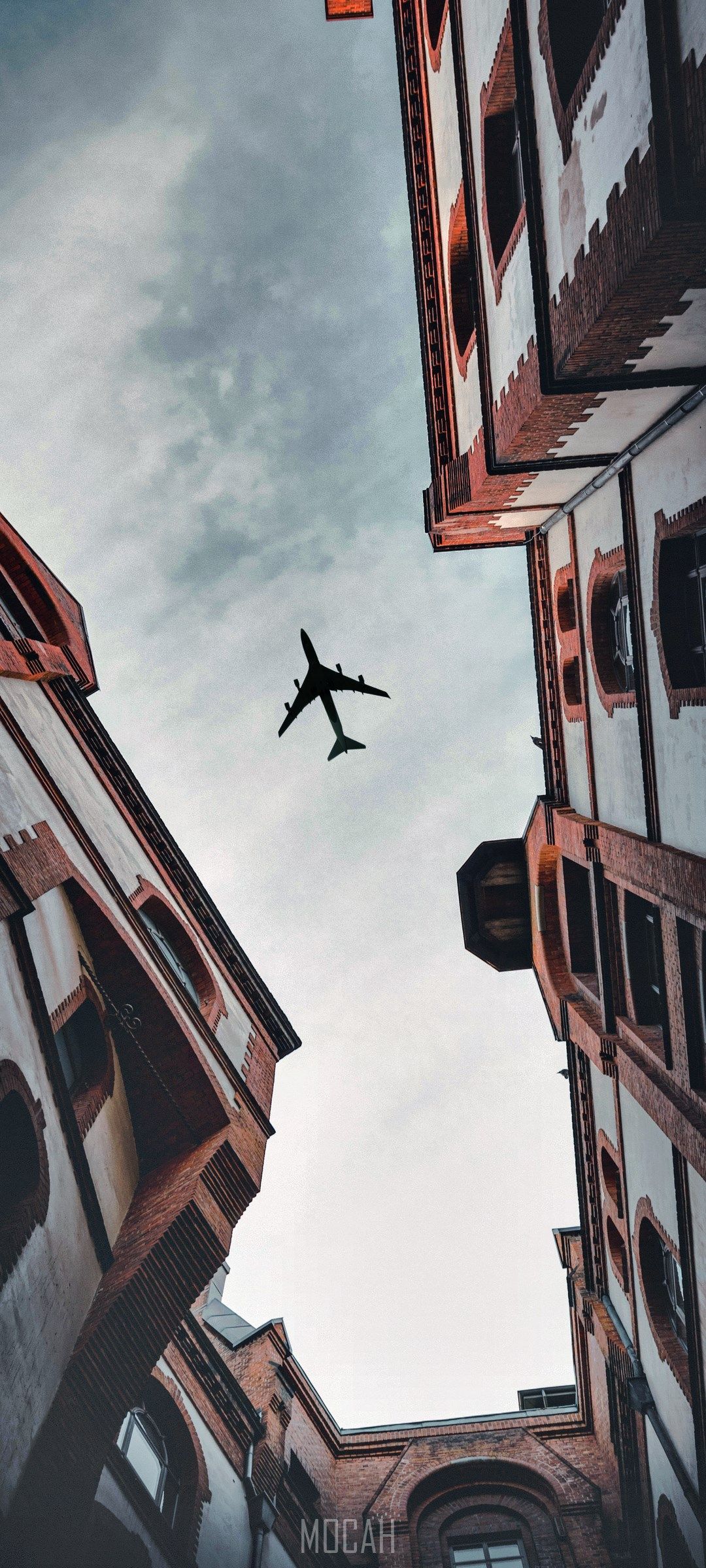 A plane flying over some buildings - Architecture, airplane