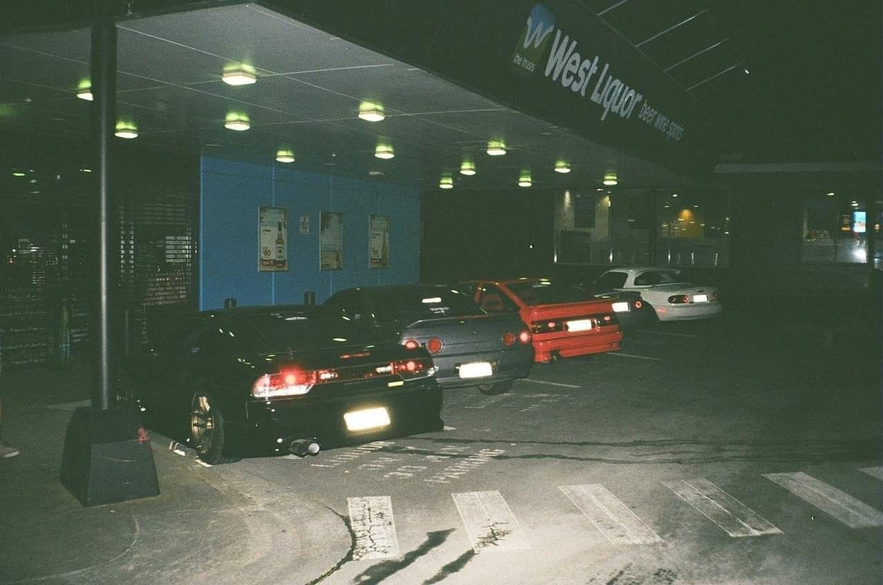A group of cars are parked in a parking garage. - JDM