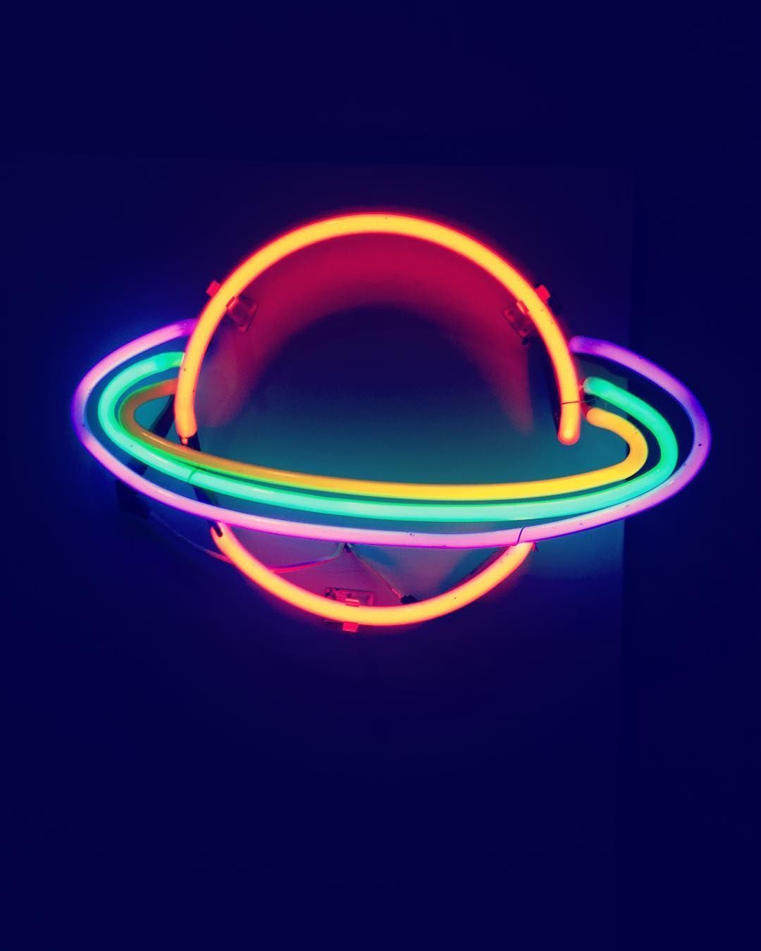 A neon light that is in the shape of planet - Neon