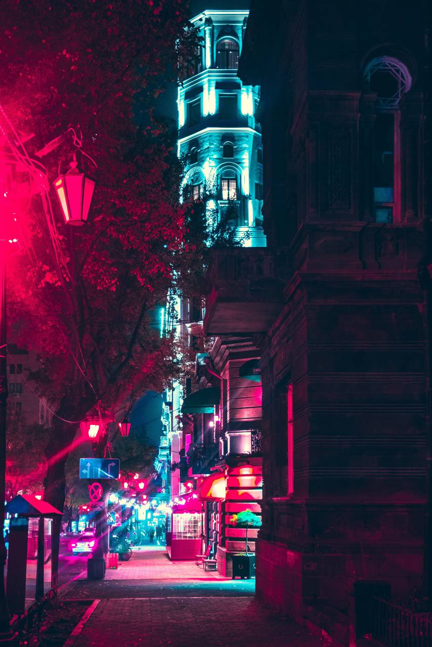 A city street at night with a pink light. - Neon