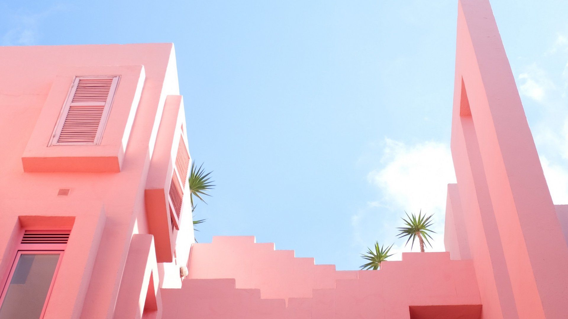 A pink building with stairs and plants - Desktop