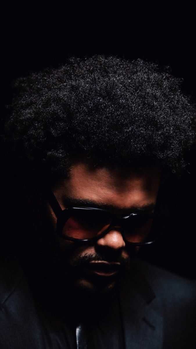 A man with an afro in sunglasses - The Weeknd