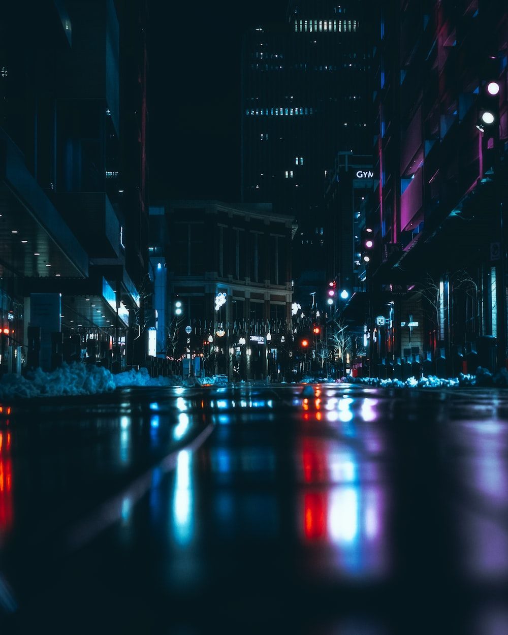 A city street at night with the lights reflecting on the wet pavement - Gym