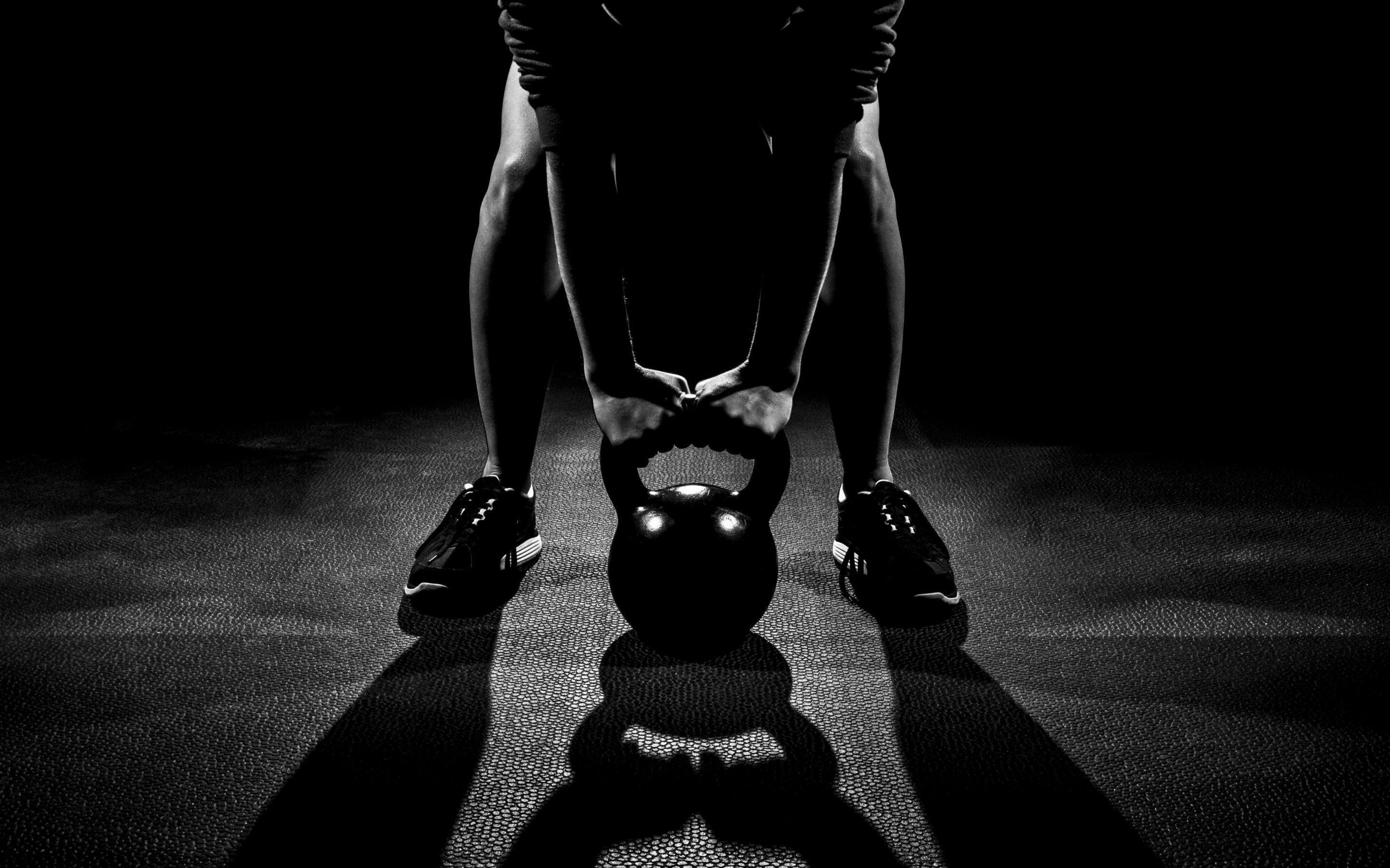 A person is doing squats with kettlebell - Gym