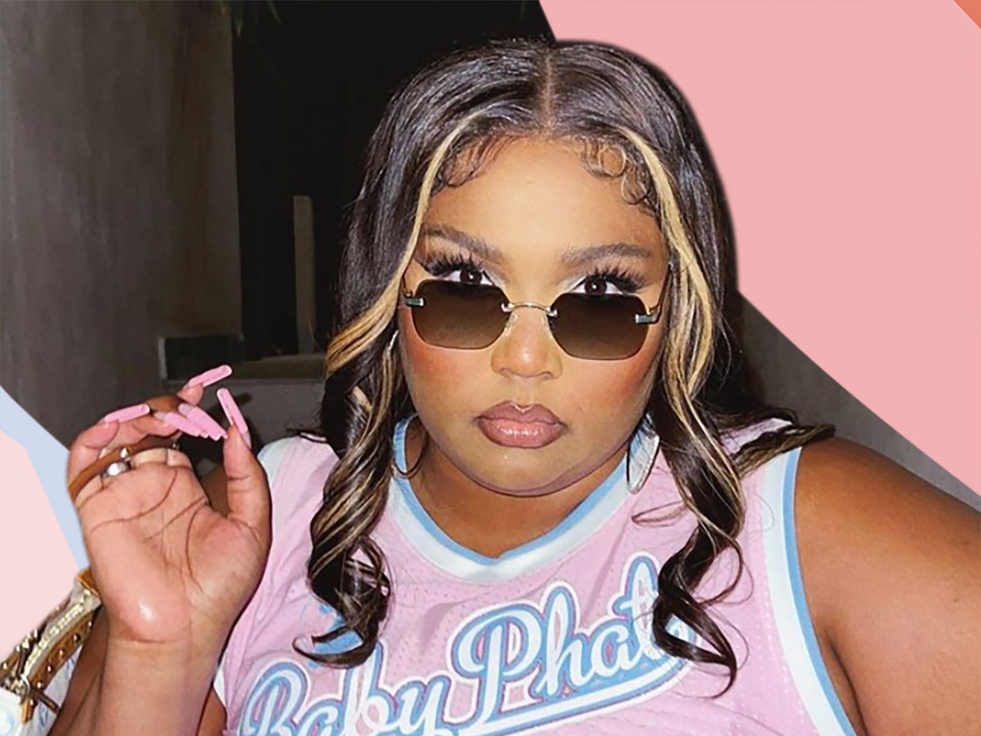 Lizzo wearing a pink basketball jersey and sunglasses, holding a pink claw. - 2000s
