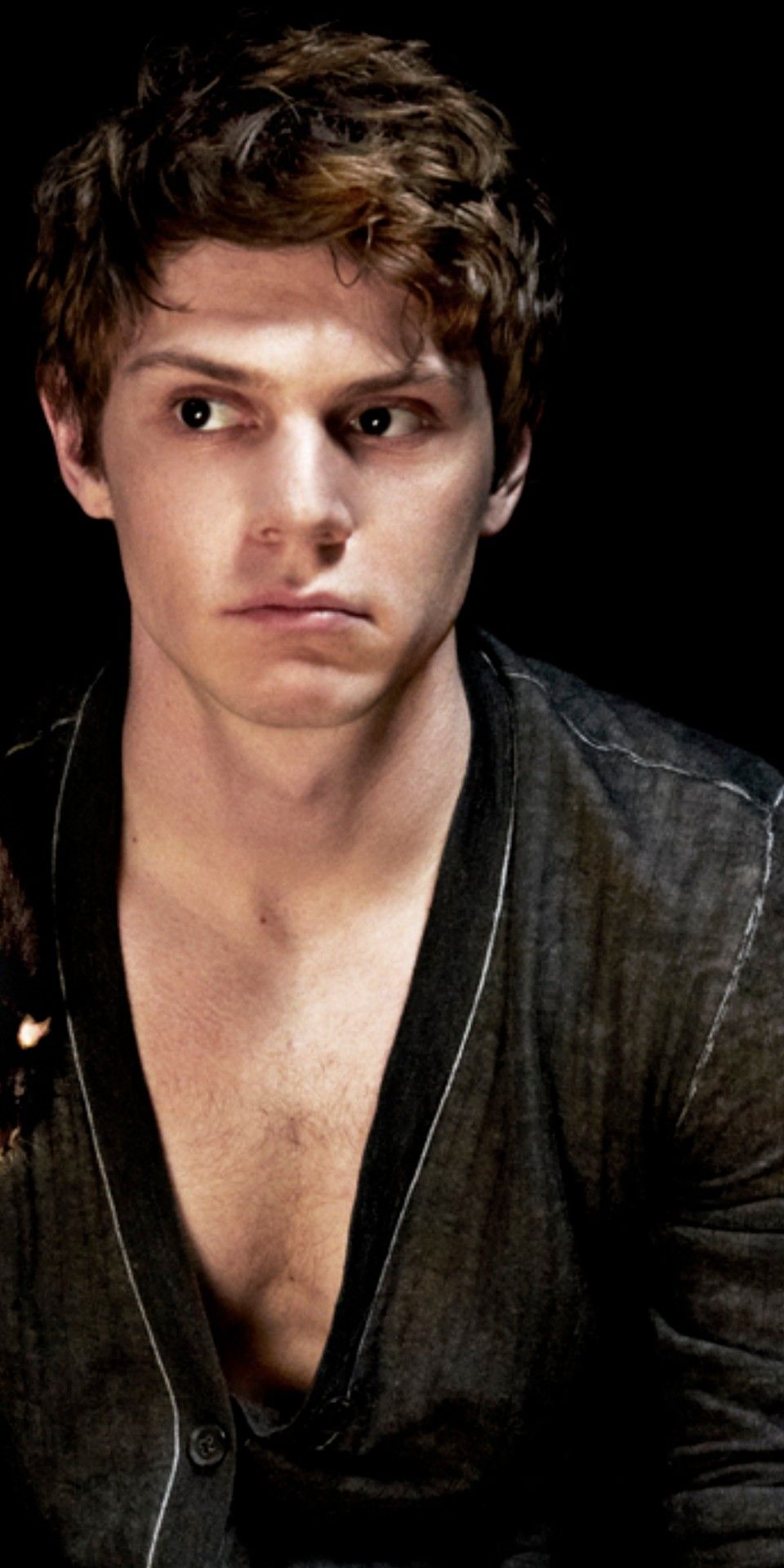 A young man with brown hair and a black shirt open to the chest - Evan Peters