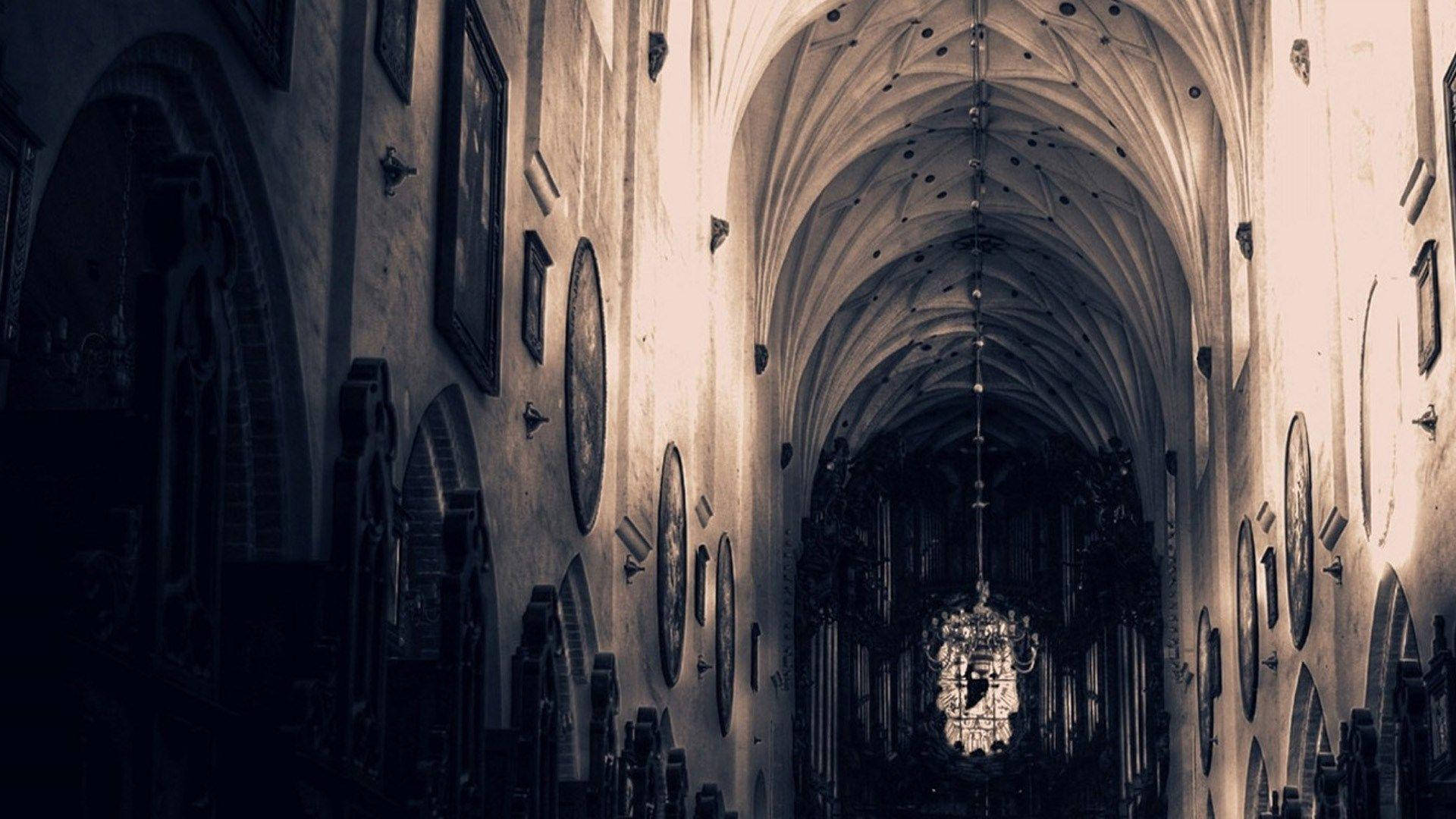 A cathedral with high arched ceilings and a chandelier hanging from the ceiling. - Dark academia