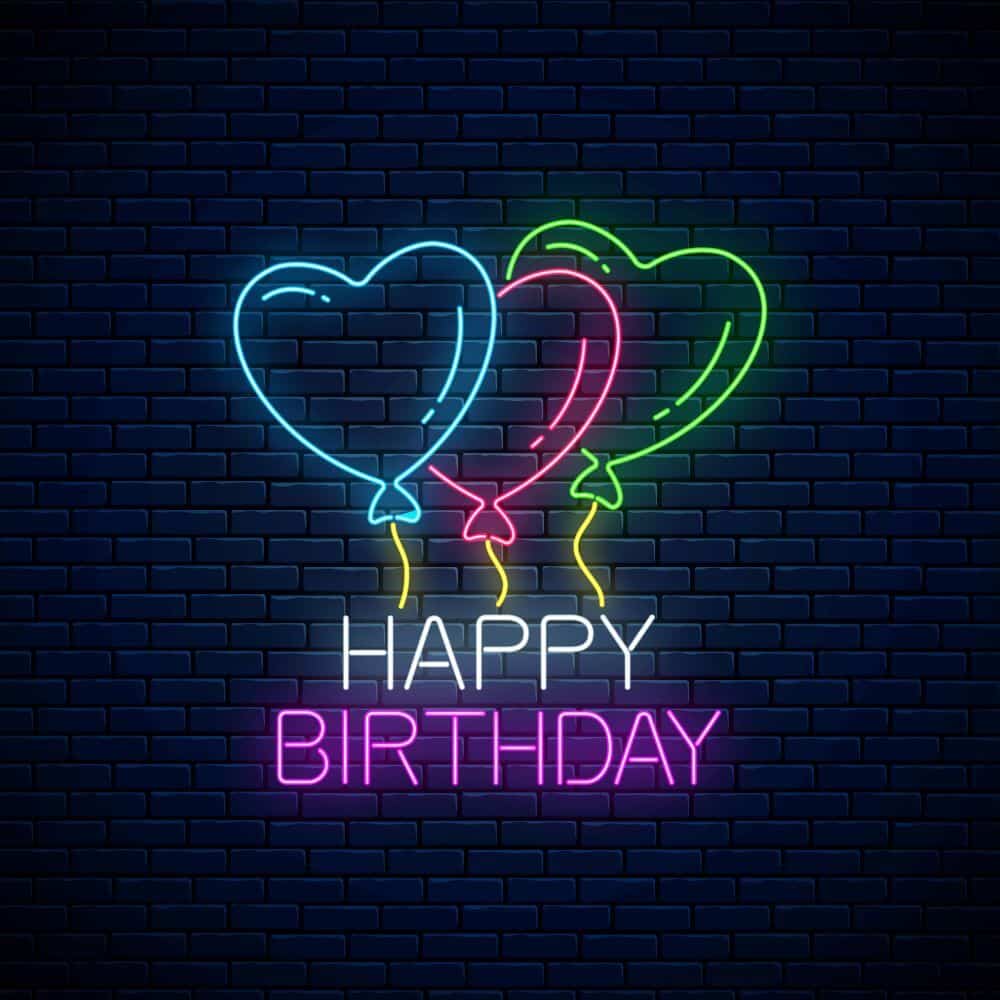 Neon sign with balloons on a brick wall background - Birthday