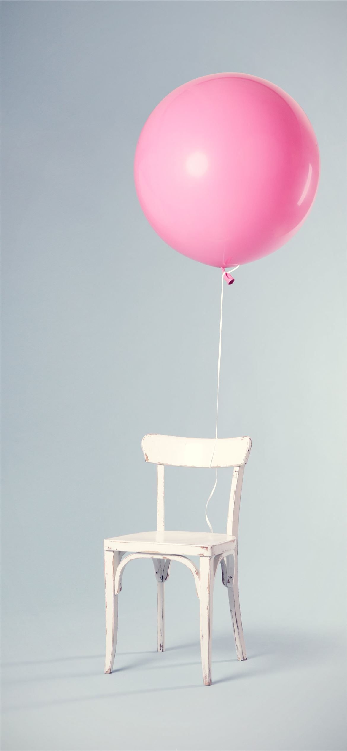 A chair with an inflated balloon tied to it - Birthday