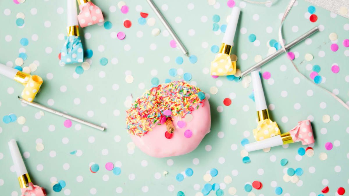 A donut with sprinkles and cake decorating tools - Birthday