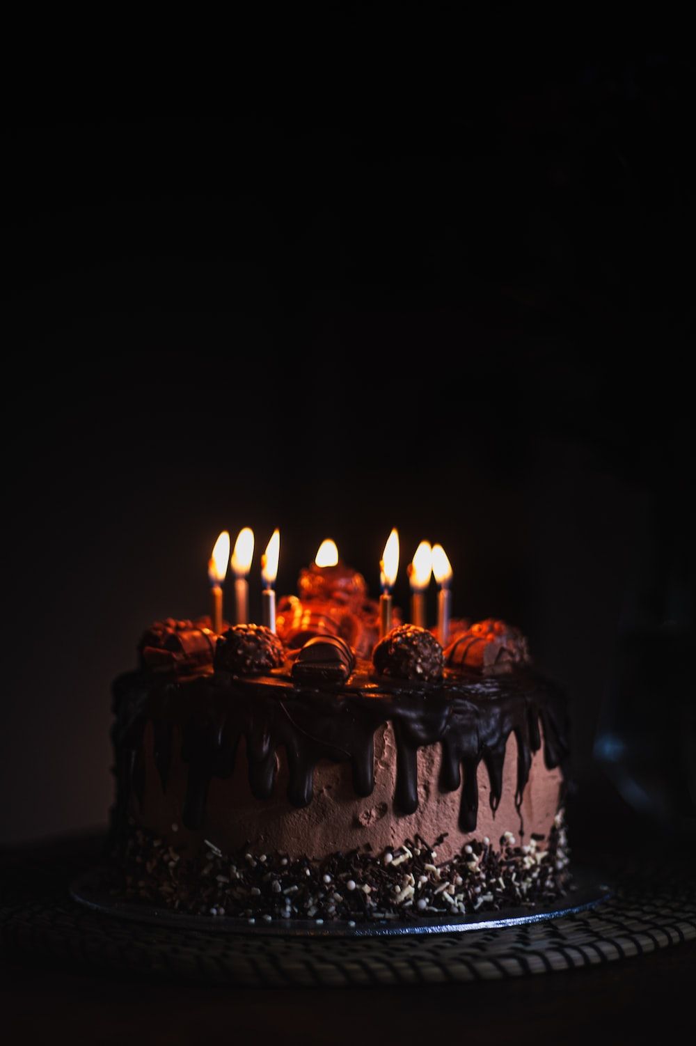 A chocolate cake with candles on a black background - Birthday