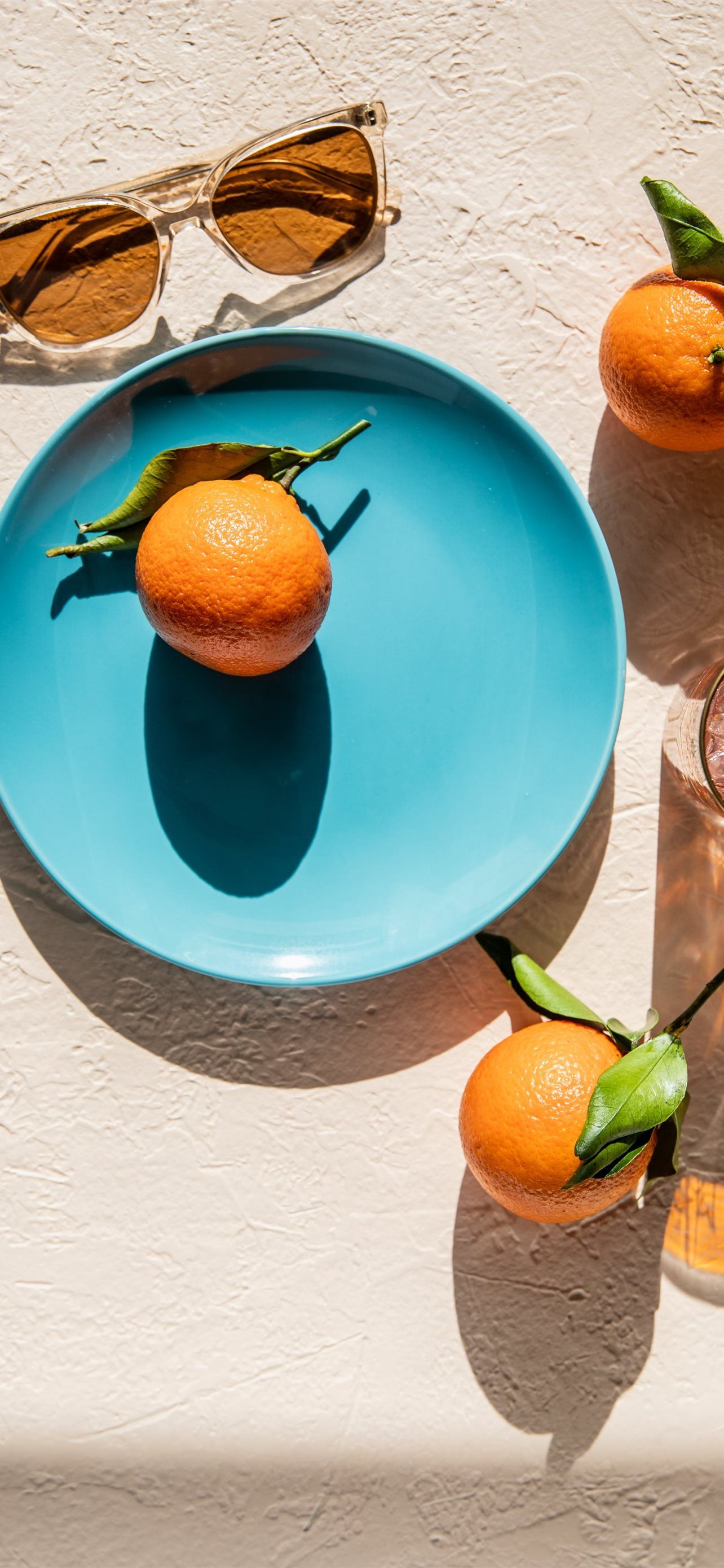 A blue plate with oranges and glasses of wine - Fruit