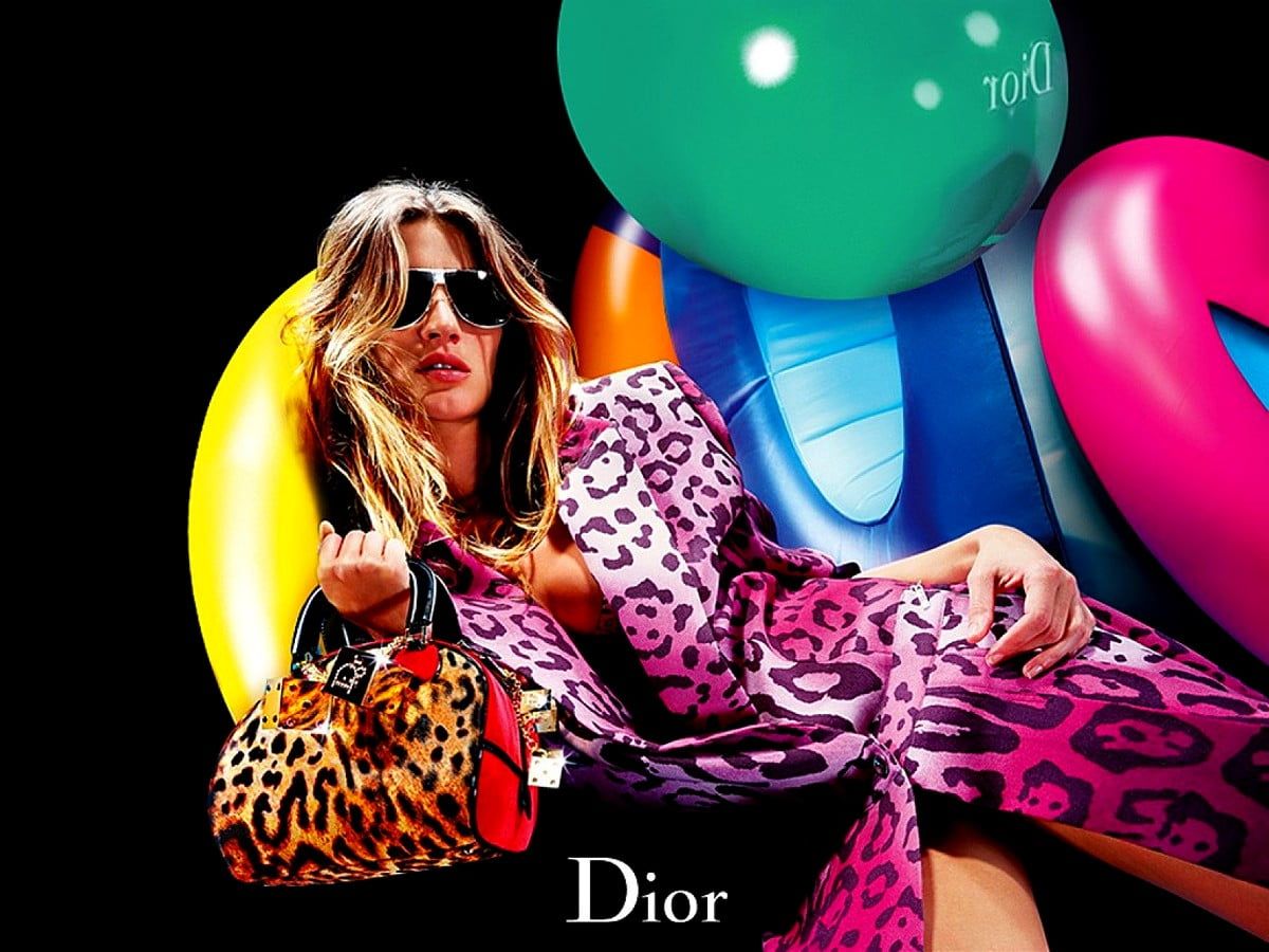 A woman is sitting on the ground with balloons - Dior