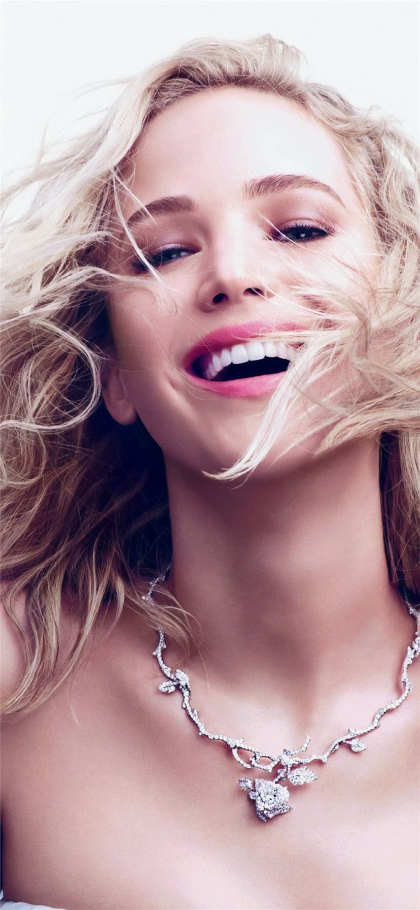 A blonde woman wearing jewelry and smiling - Dior
