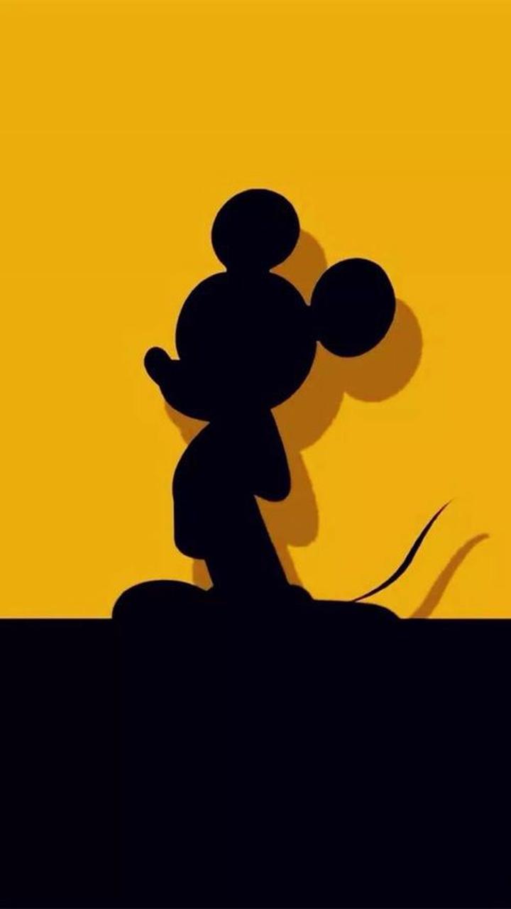 The silhouette of mickey mouse on a yellow background - Mickey Mouse