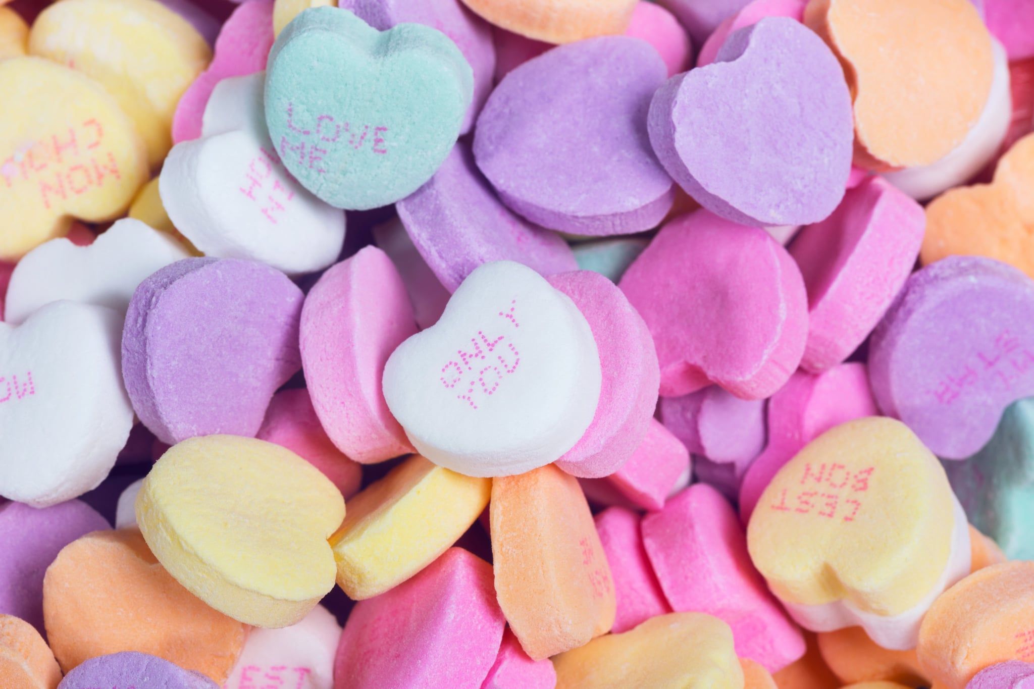 A pile of heart shaped candies with messages on them - Candy