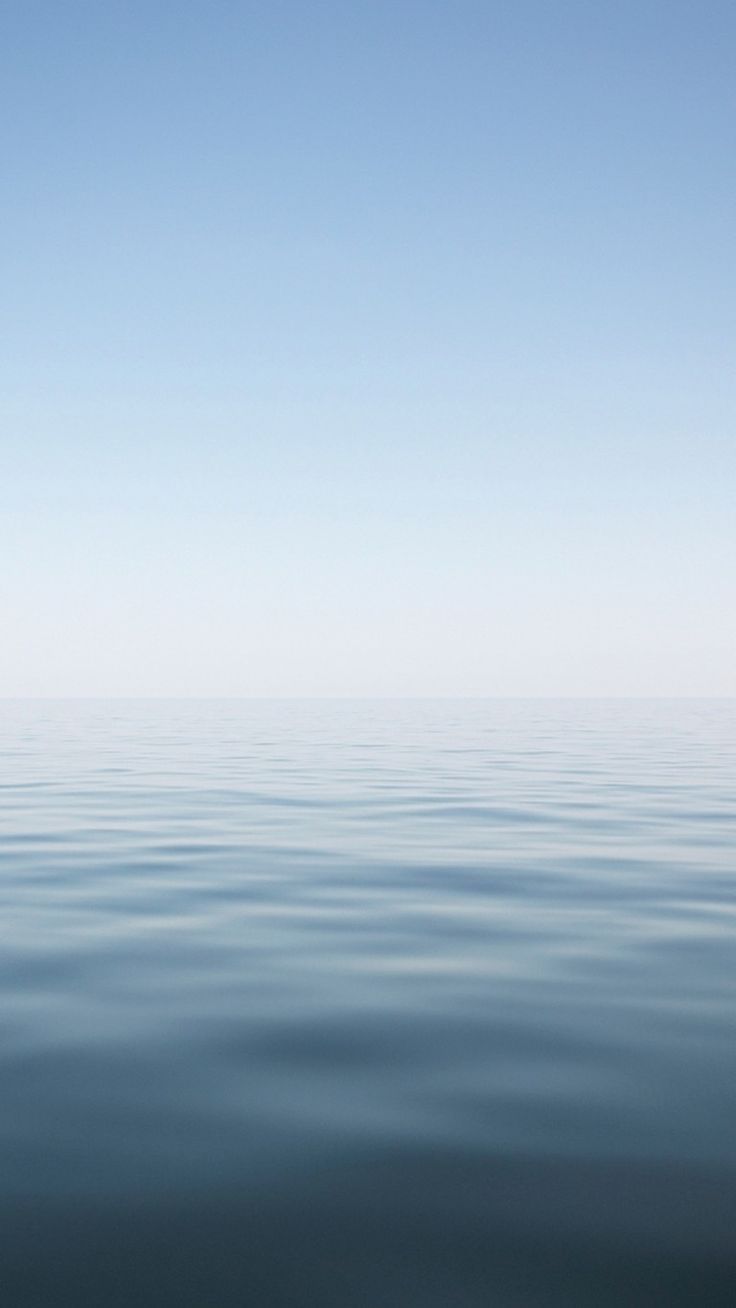 A serene image of the ocean with a clear blue sky above. - Calming