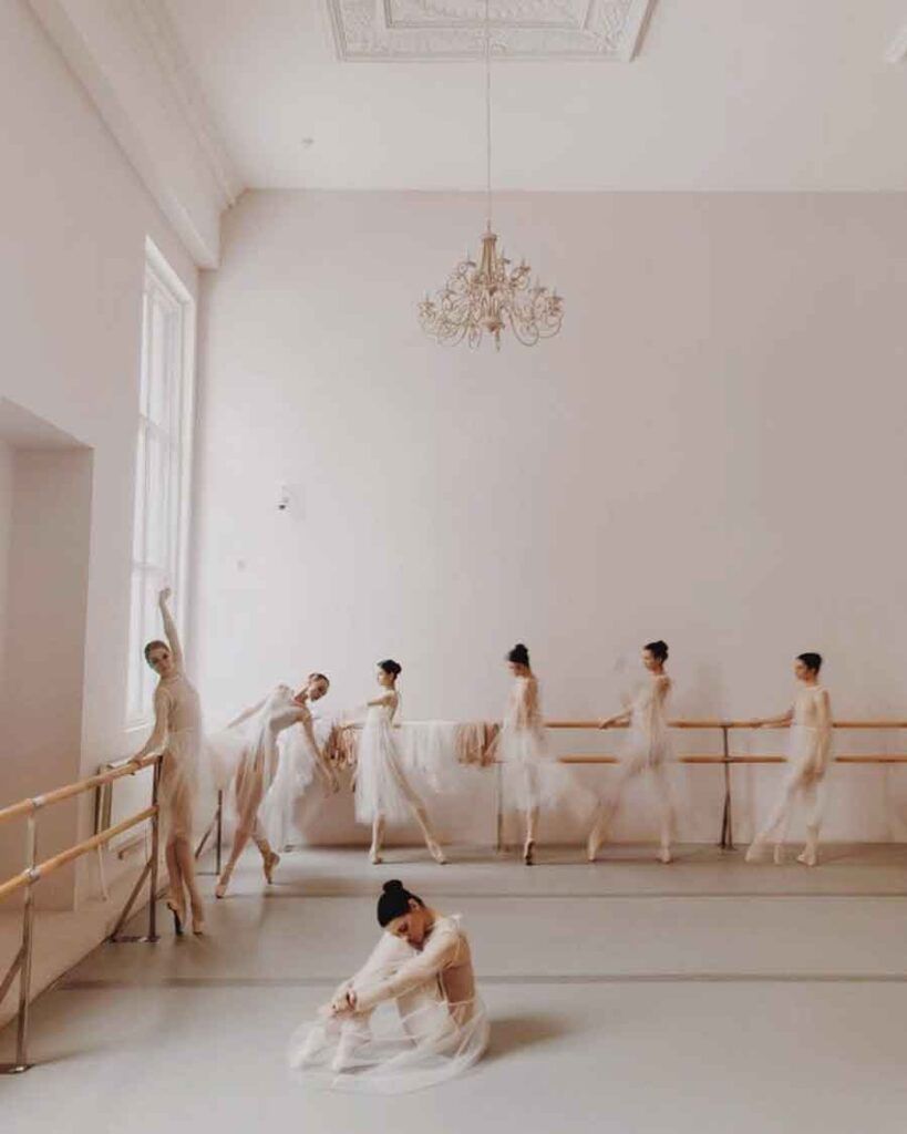 A group of ballerinas in white dresses practice in a white room. - Dance, ballet