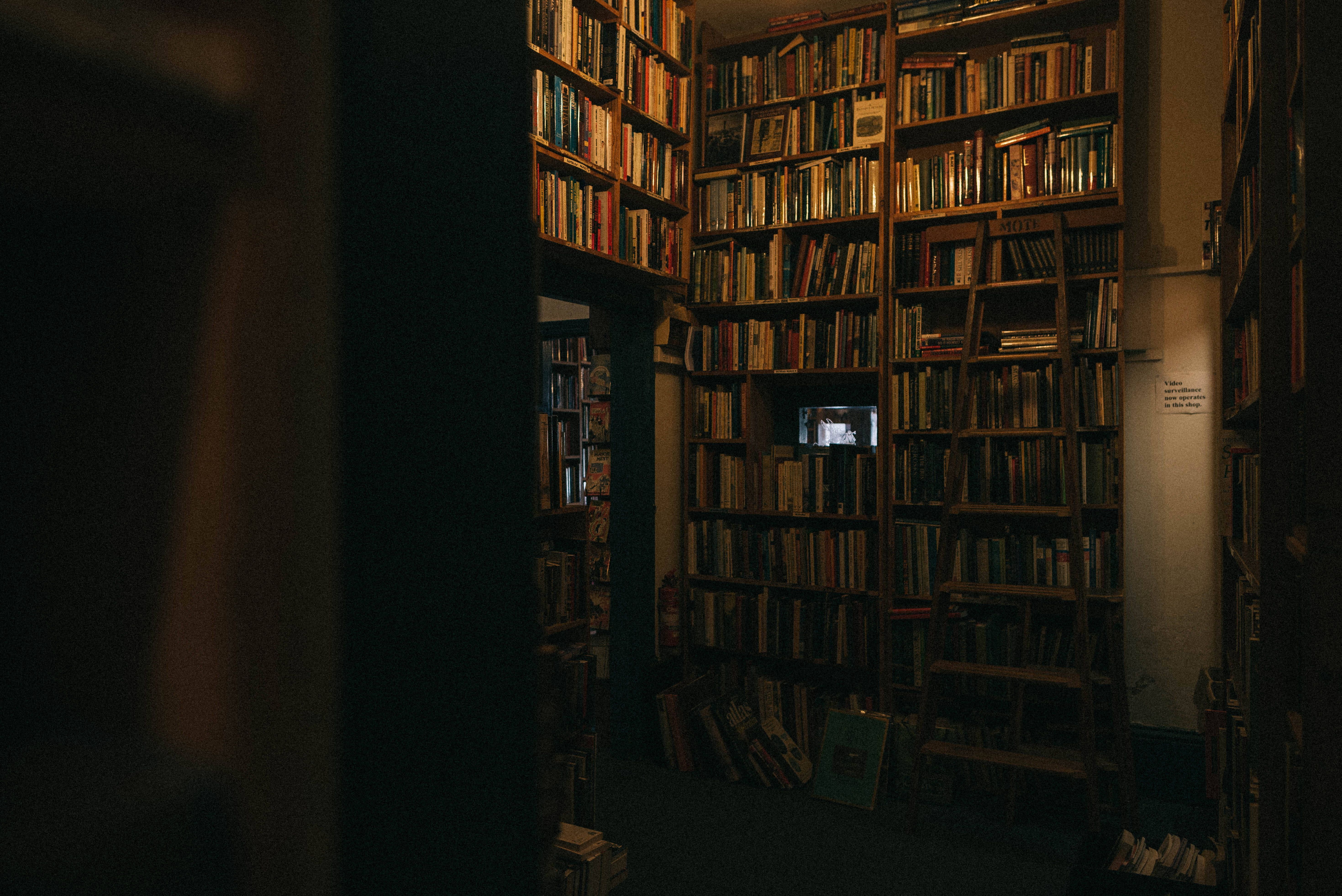 A dark room with bookshelves full of books - Library