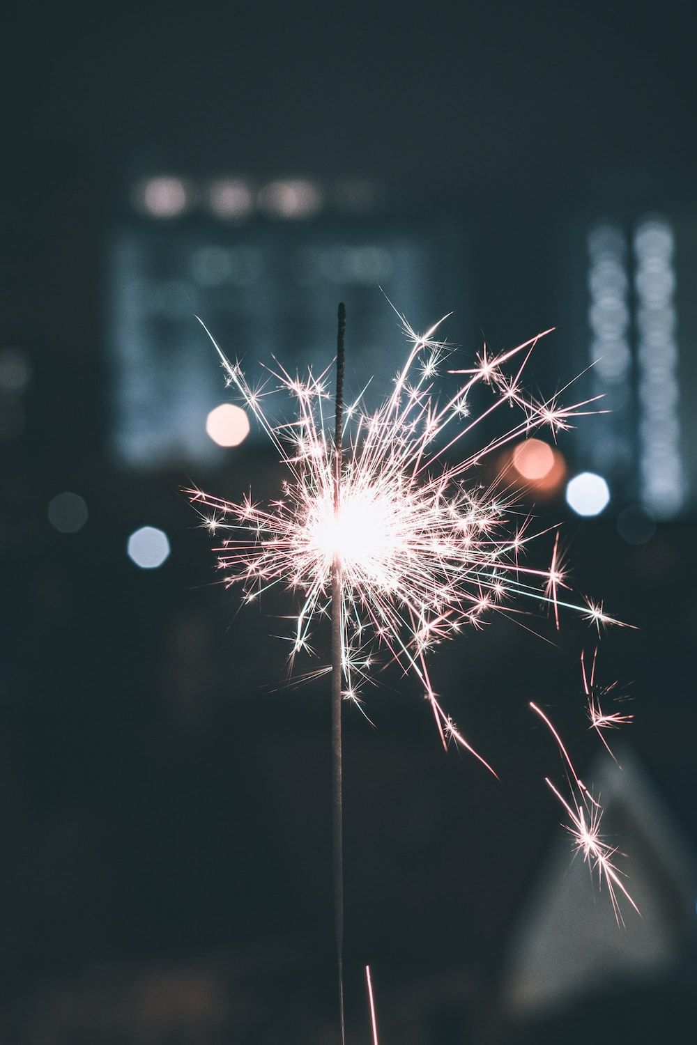 A sparkler burns in the dark, creating a bright and beautiful display. - New Year