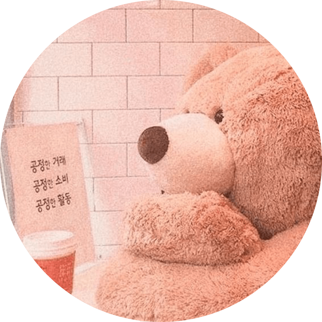 A teddy bear sitting in front of a sign that says 