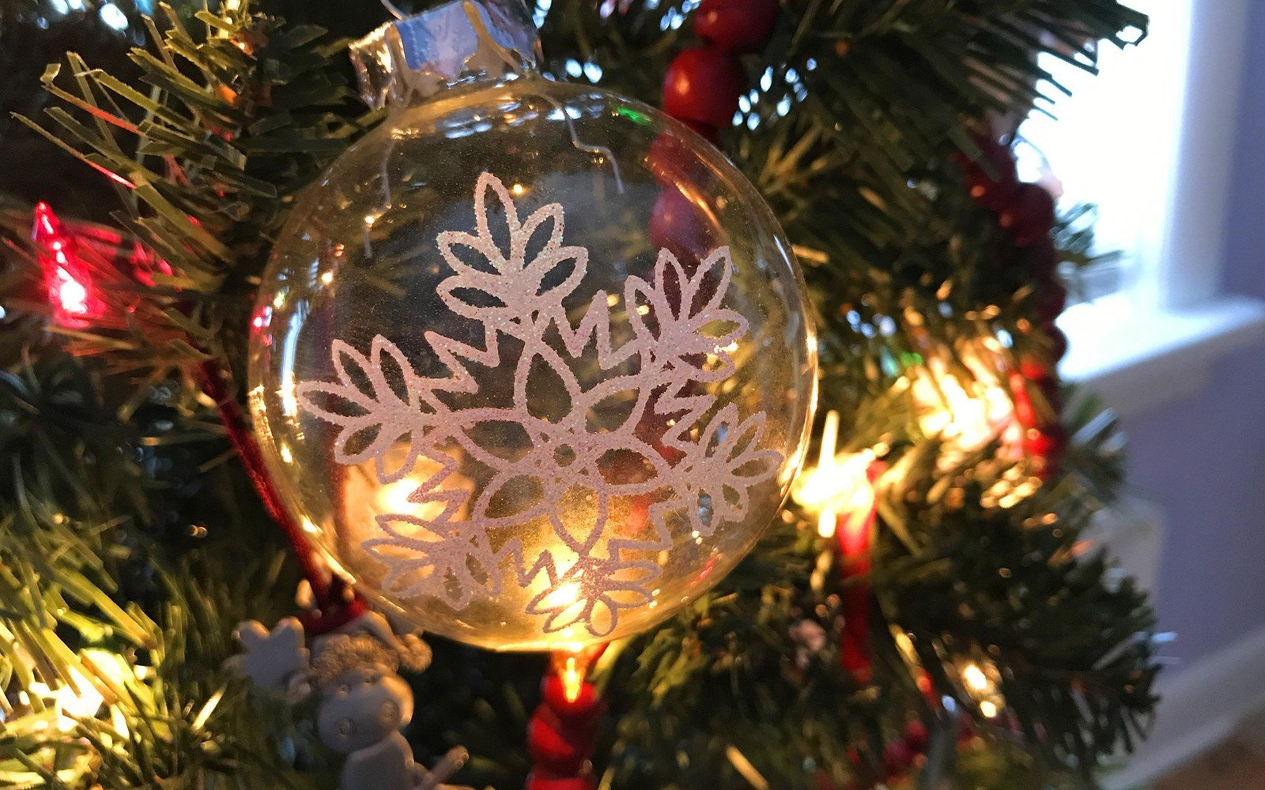 A glass ornament hanging on the tree - Christmas lights