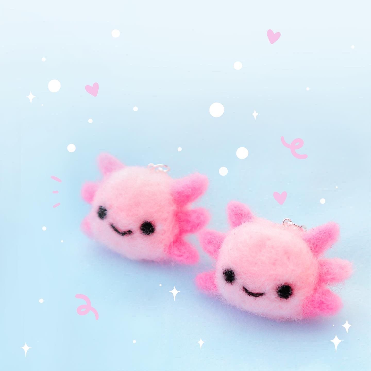 Two pink axolotl phone straps on a blue background - Axolotl