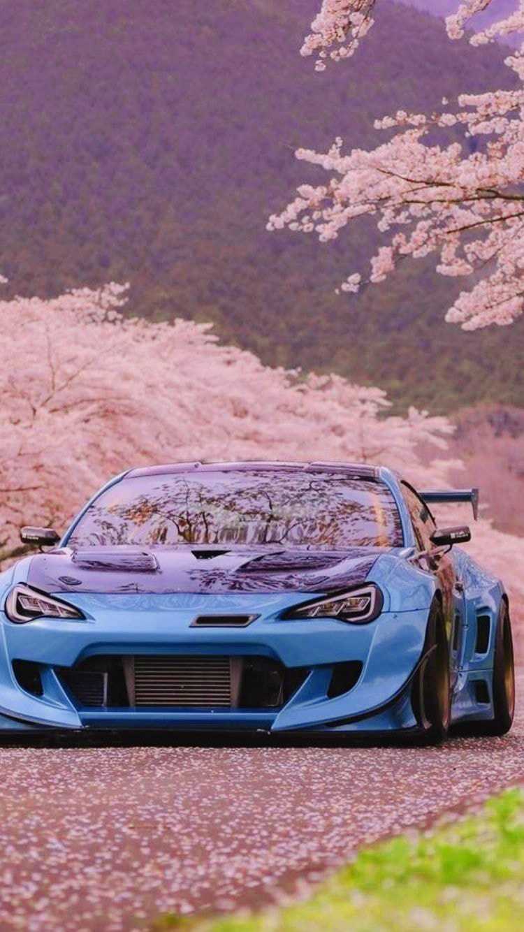 A blue sports car driving down the road - JDM