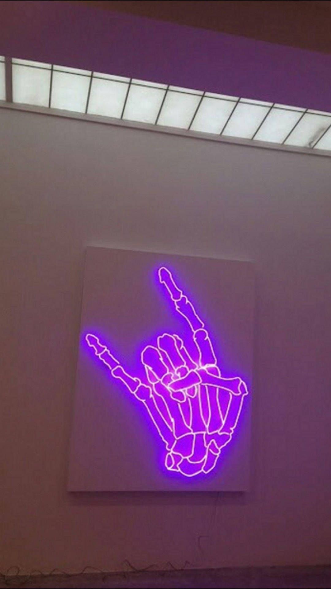 A purple neon sign that is on the wall - Rock