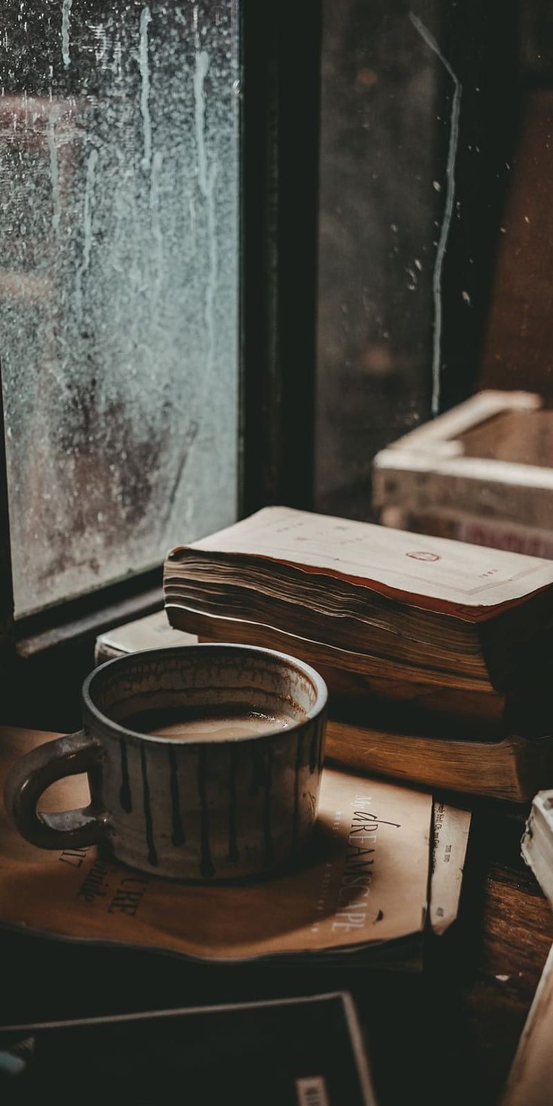 A cup of coffee and a book on a table - Coffee